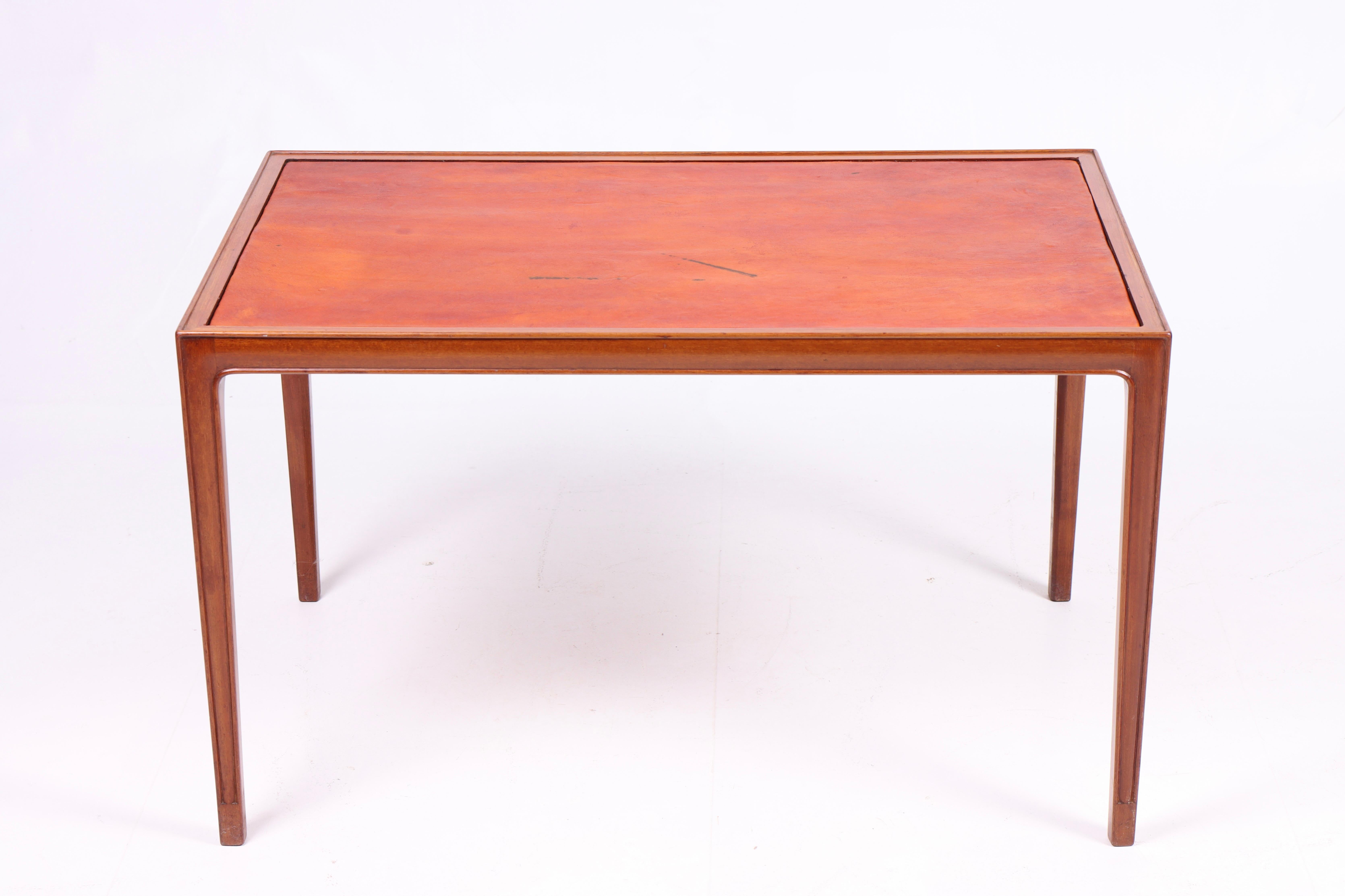 Low table in mahogany and patinated leather. Designed and made in Denmark. Great condition.

 