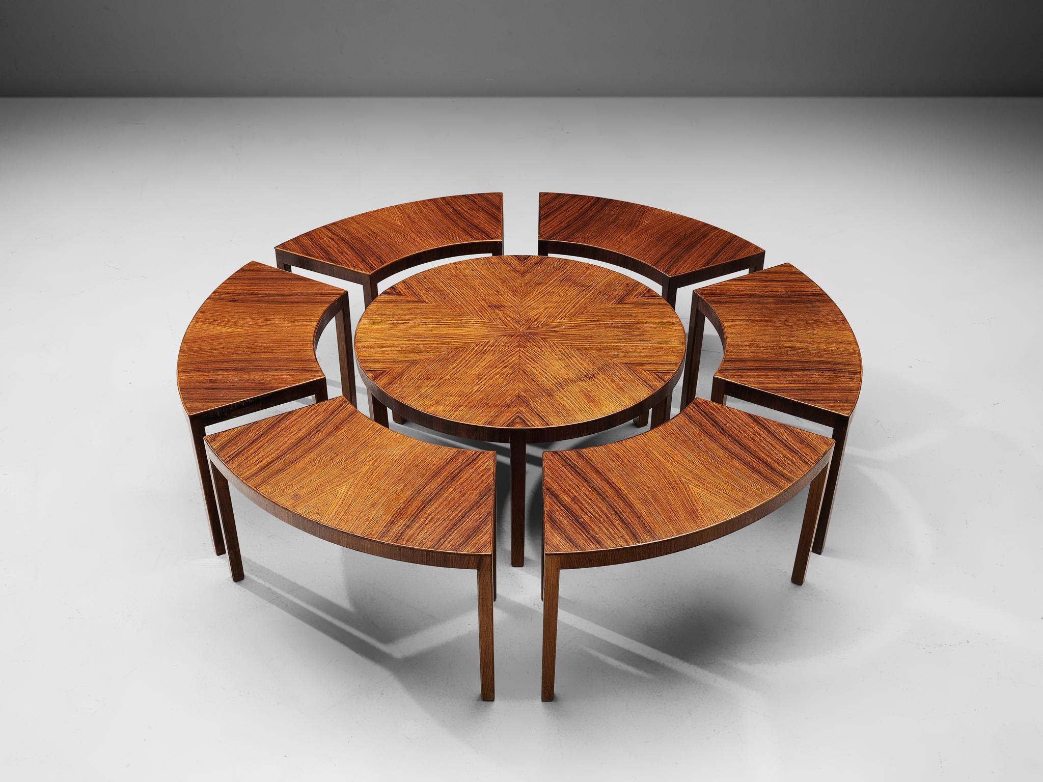 Coffee table, teak and wood, Italy, circa 1970

A modular coffee table, consisting of 8 pieces that form together one large round coffee table. The legs are rectangular shaped and made of wood. The walnut table tops have a warm, color and the grain