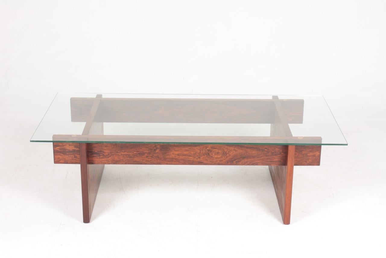 Low table in rosewood with glass top. Designed and made by Svend Langkilde. Made in Denmark in the 1960s. Great original condition.