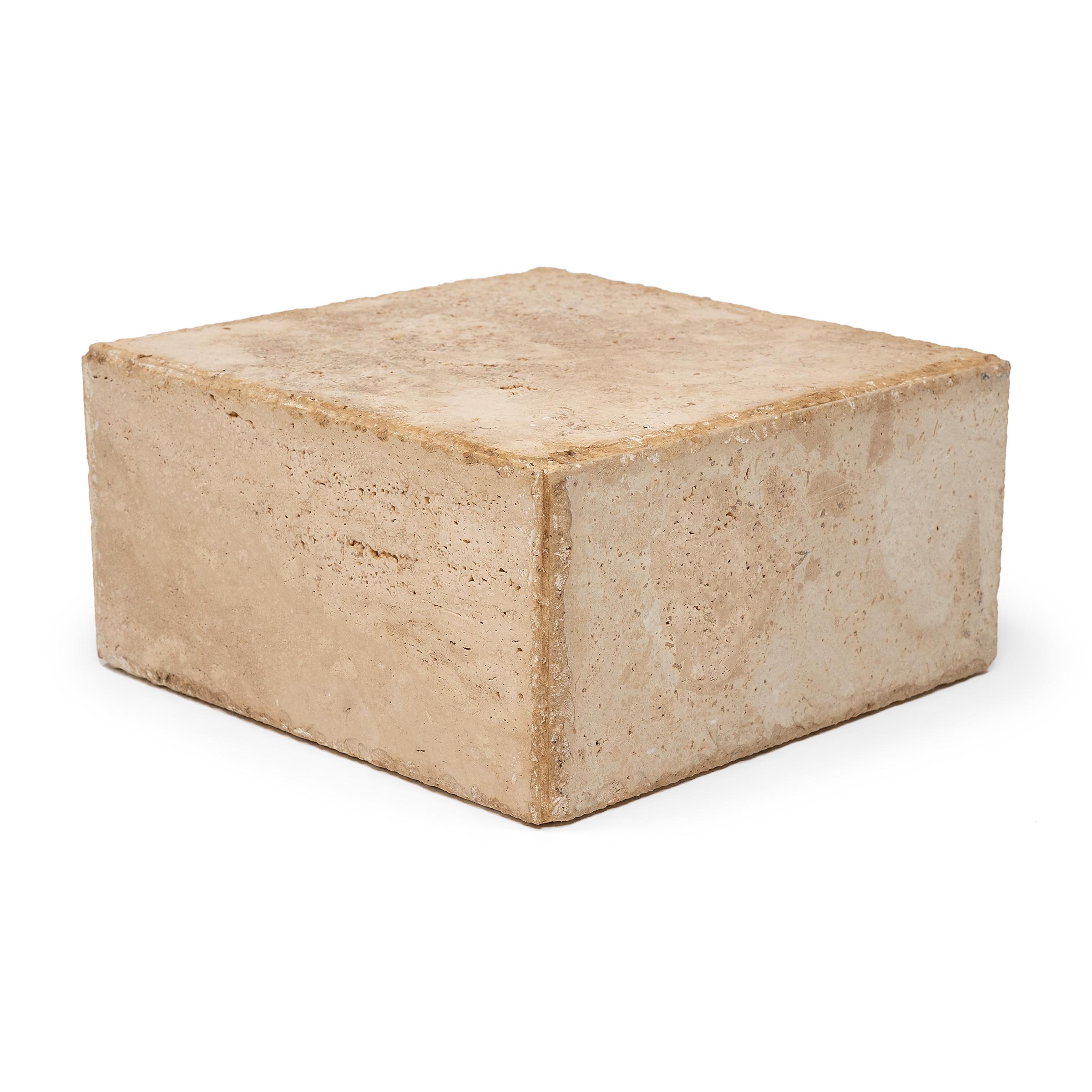 This minimalist block-form pedestal is hand-carved of solid travertine marble by a local Chicago artisan. Shaped with clean lines and balanced proportions, the low display stand exemplifies Organic Modern style with chiseled edges, smoothed sides