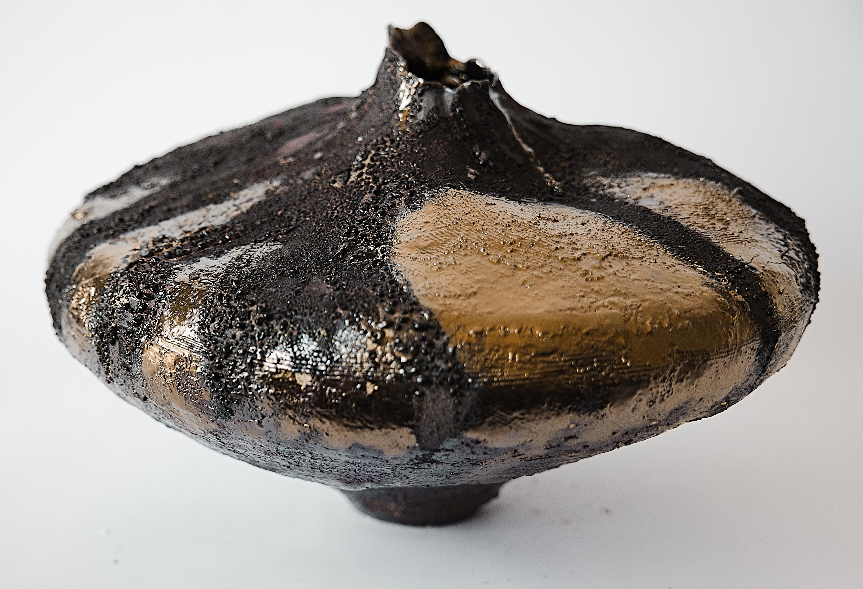 Ti presentiamo il Moody Lava Moon Collector, disponibile in esclusiva presso gli Studio A. Questo grande vaso arrotolato a mano presenta una finitura opaca con strati di argilla pesante e barbottina e un'aggiunta di smalto lavico, incarnando la