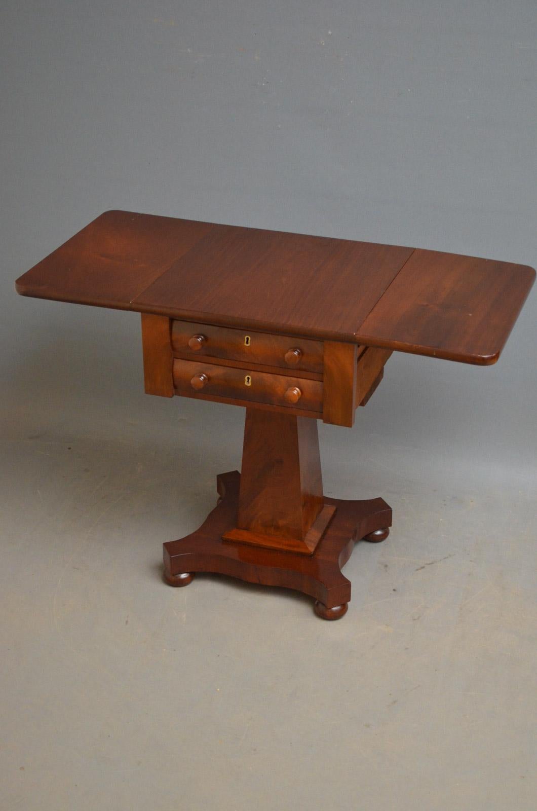 Sn962 William IV drop leaf, work table of low design, having rounded, rectangular top, two shaped, flamed mahogany drawers with original turned knobs and brass escutcheons, standing on column terminating in platform base and bun feet. This antique