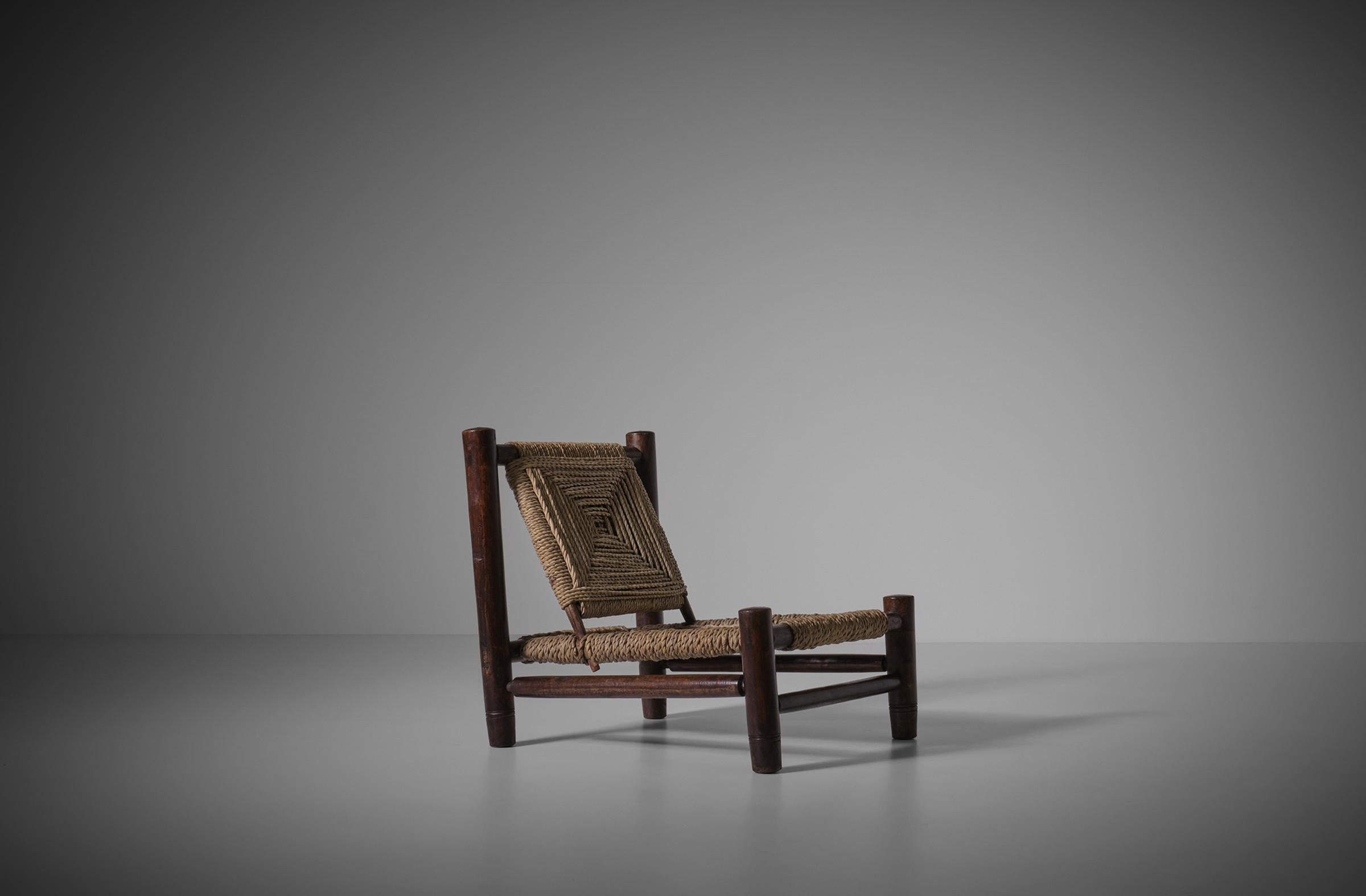 Low lounge chair, France 1960s. Rustic yet modern design made of stained wooden frame and a rope seat and backrest in a beautiful woven pattern. The modernist lines go very well together with rustic use of material. In very good original condition