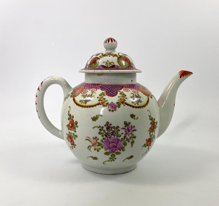 Lowestoft porcelain teapot, c. 1785. The large teapot, finely painted in the Curtis pattern, of floral sprays, beneath swags, and shaped cell panels. The cover similarly decorated, and having a bud finial.
Bother the spout, and the handle, painted