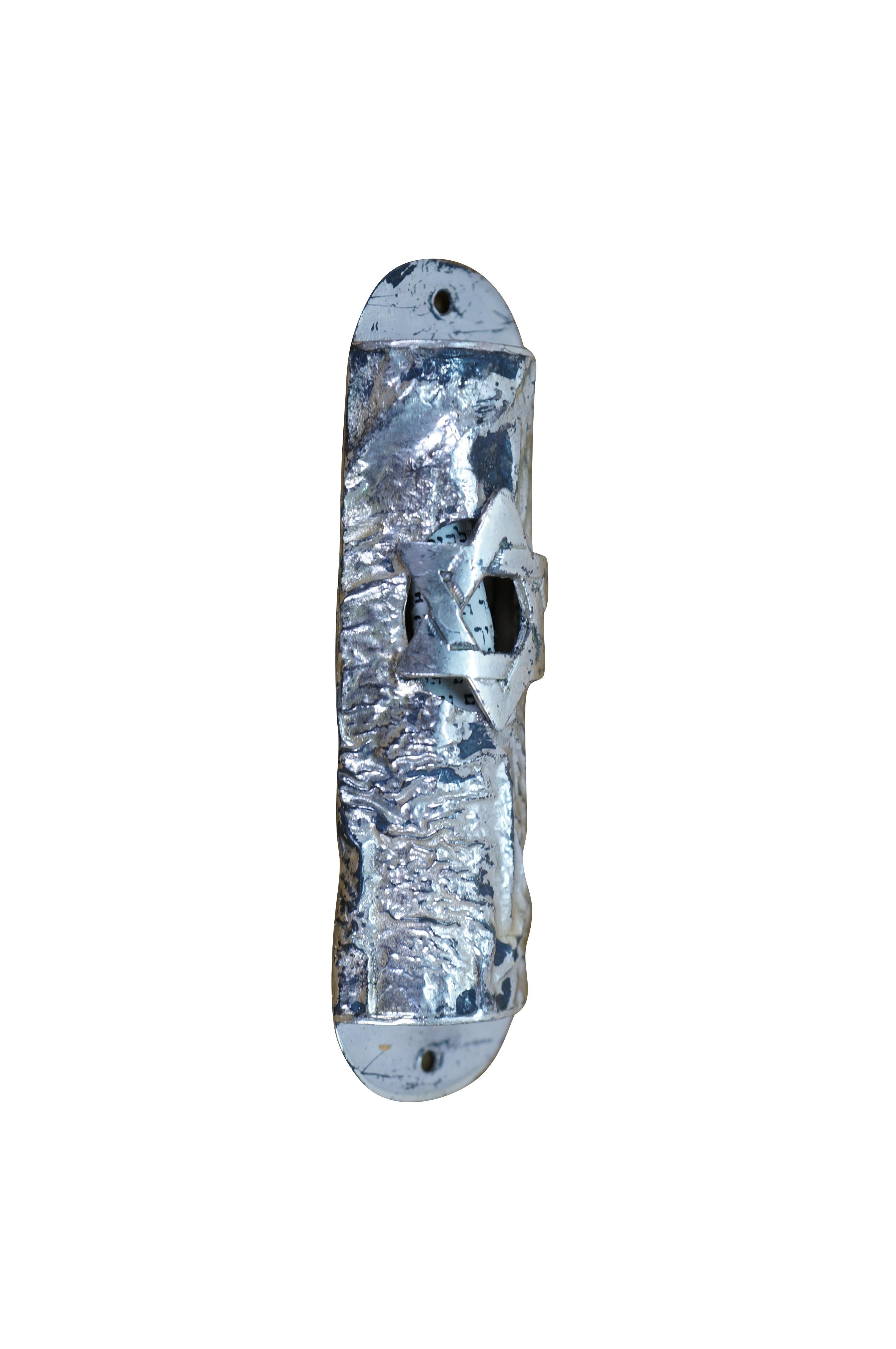 Mezuzá vintage Lowry de plata de ley con rollo de la Torá. Forma cilíndrica con textura de corteza de árbol y estrella de David perforada que deja entrever el pergamino de su interior. Marcado Lowry Sterling en el reverso.

Dimensiones:
0,875
