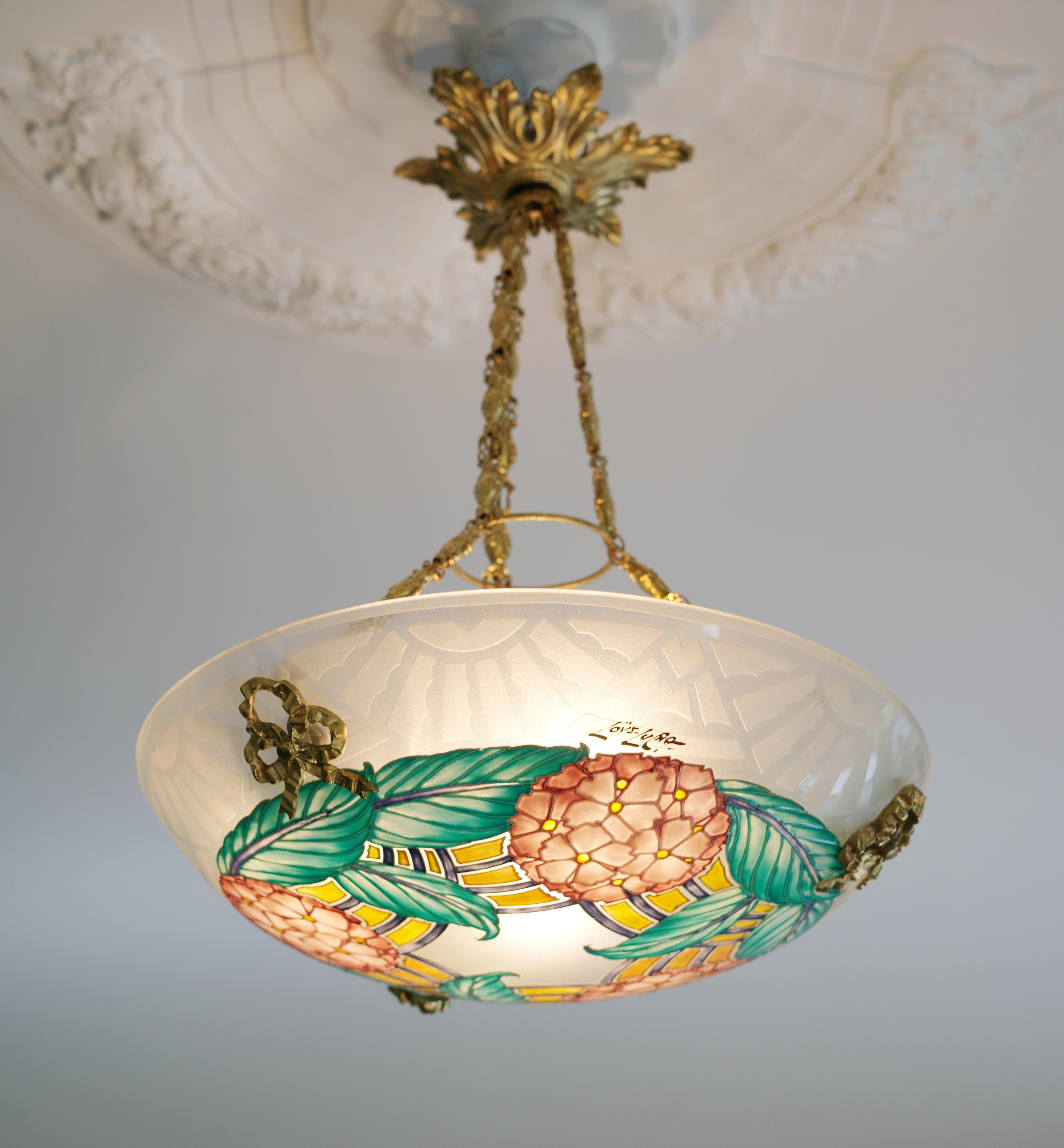 French Art Deco pendant chandelier by LOYS LUCHA (Paris), France, 1920s. Etched (edge) and enameled (pattern) glass shade hung at its delicious bronze (canopy & hidden-holes) and brass (chains). Take a look at that fixture. Height : 17.3(44cm) can