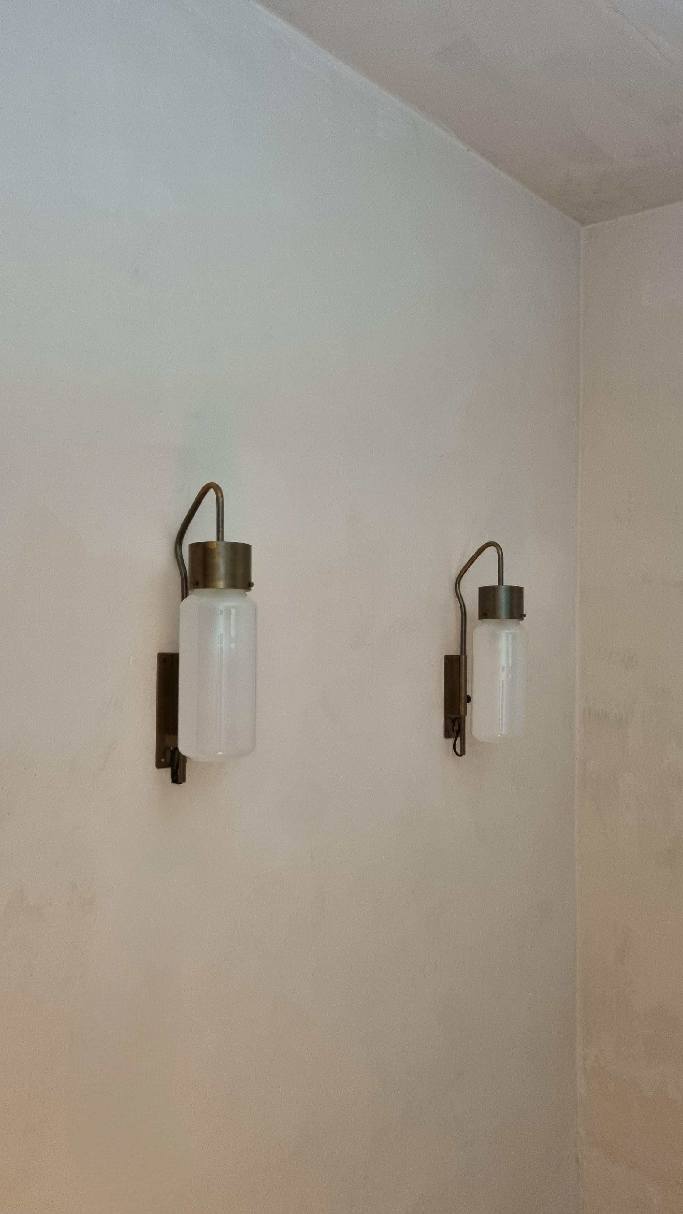 Iconic LP 10 wall lamps designed by Luigi Caccia Dominioni for Azucena in 1958.
Brass swivel frame, white frosted glass, excellent condition, maker's mark, first production.

A figure of reference for contemporary designers, Caccia Dominioni plumbed