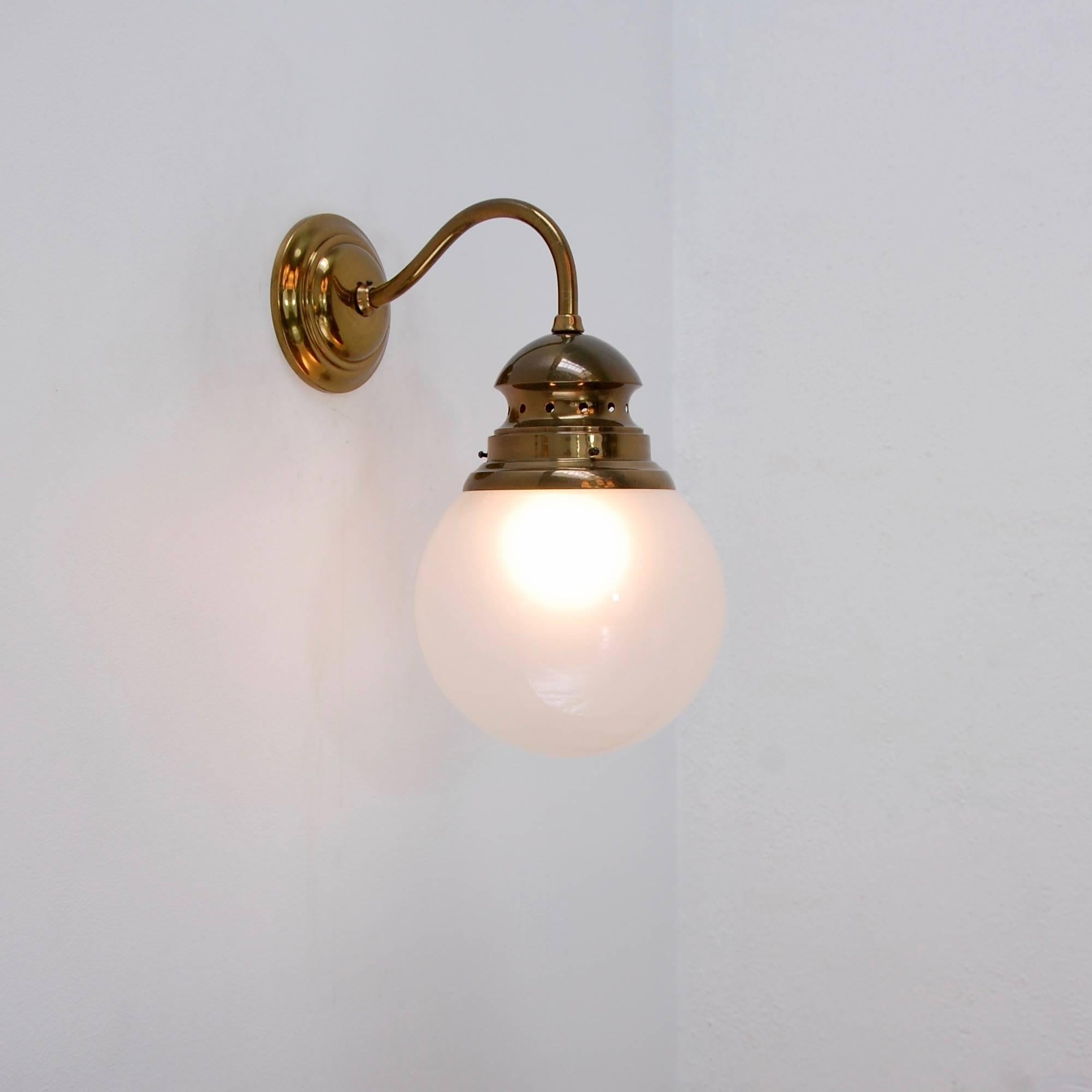 2 Italian wall lights designed by Luigi Caccia Dominioni for Azucena in naturally aged brass, and glass globe frosted inside. Single medium E26 based socket per sconce. Priced individually. 

We are aware that they are commonly used in a reversed