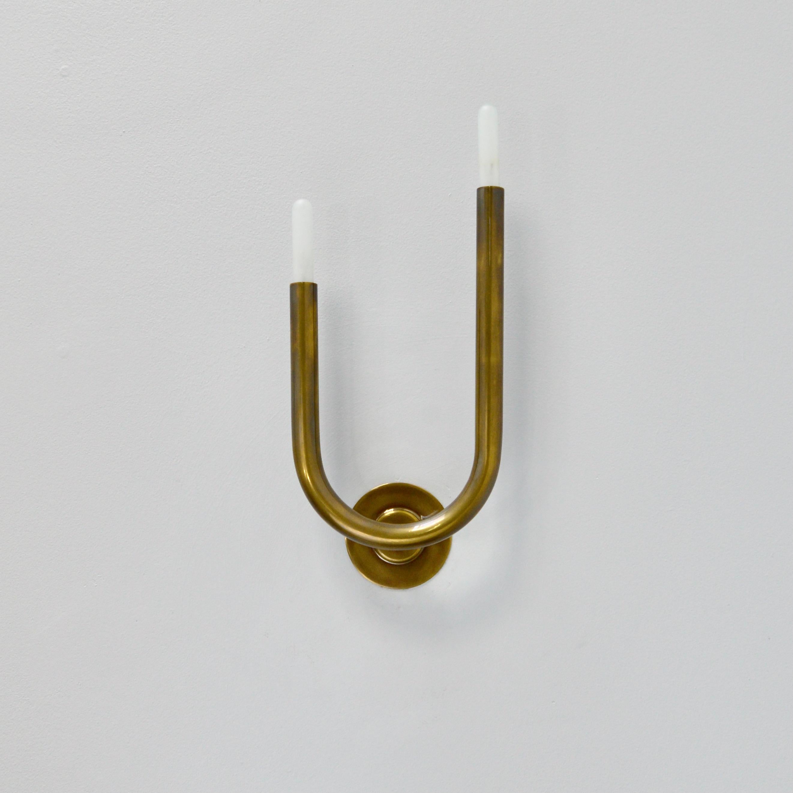 Superb and sleek modern LU Wall sconces by Lumfardo Luminaires in patinated un-lacquered brass. Candelabra based sockets. Lightbulbs included. Priced as a pair. (left and right sconces)

Measurements are with bulbs.