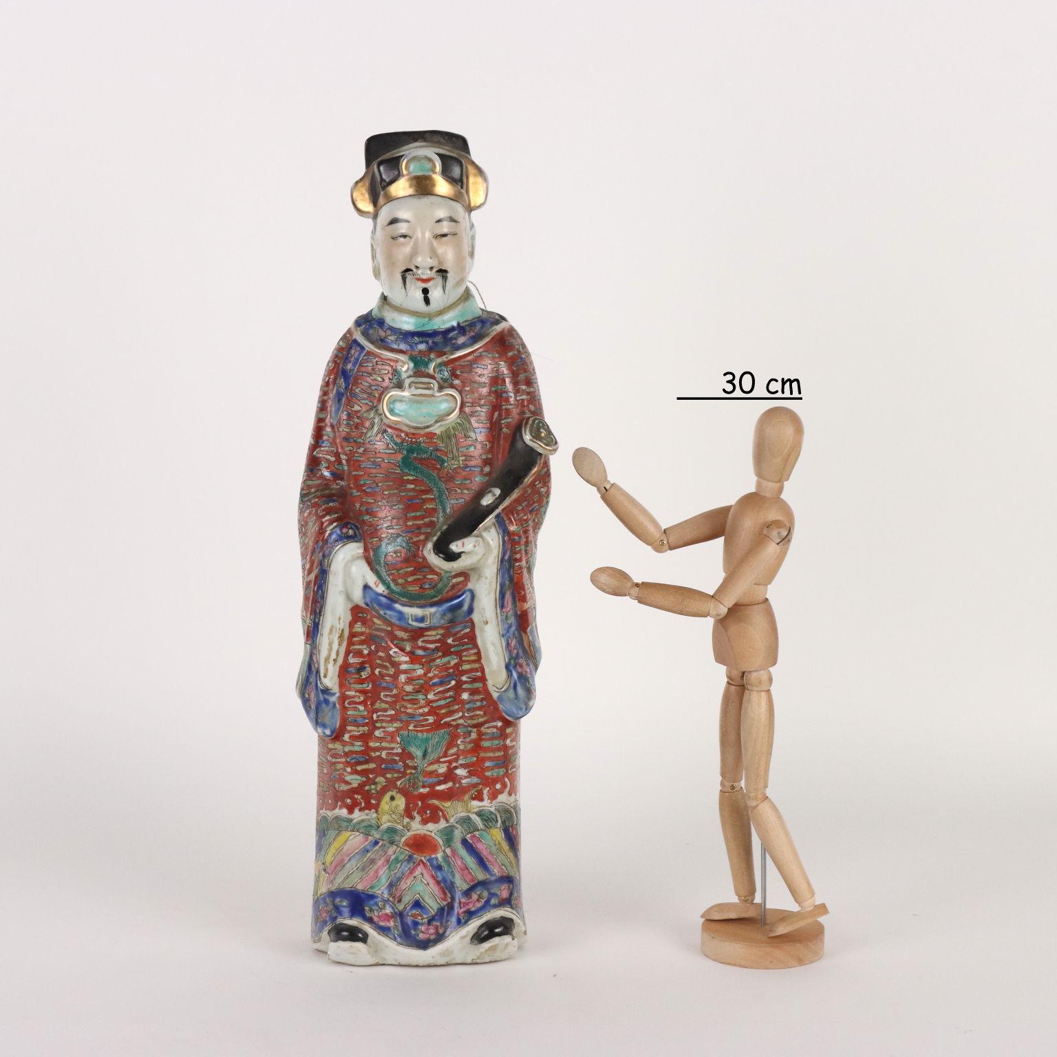 Lu Xing porcelain figure depicted in a long and rich robe and holding a Ruyi scepter in his left hand. The statue is decorated with polychrome enamels with a wealth of details. The traces of his long mustache and horsehair beard are still present on