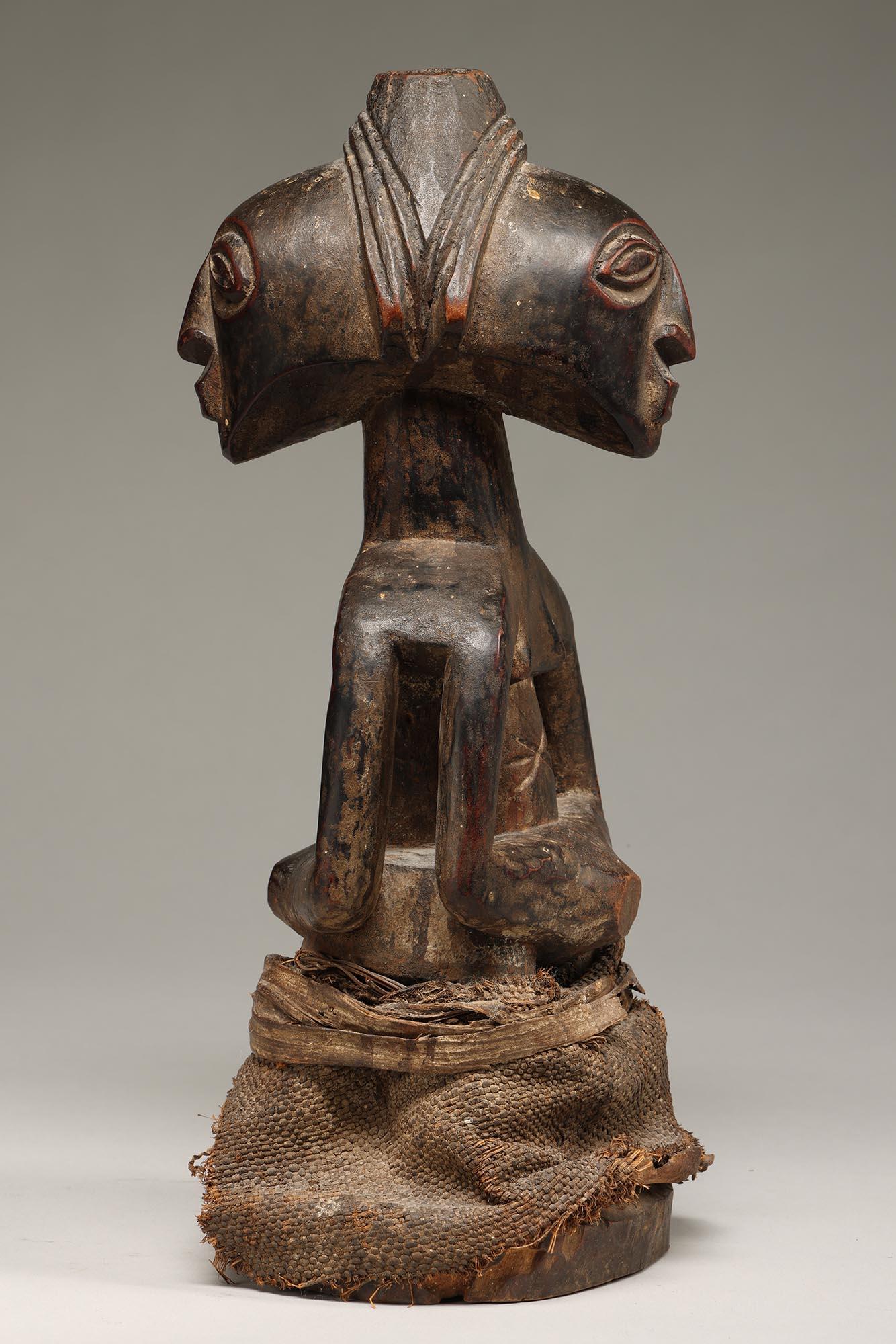 Klassische Luba Kabeja Janus Doppelfigur oder Fetisch mit Rockfetisch aus abgedunkeltem Holz mit polierter und abgenutzter Patina.  Auffällige Augen und sowohl männliche als auch weibliche Figuren, die sich mit den Händen den Bauch halten.  Öffnung