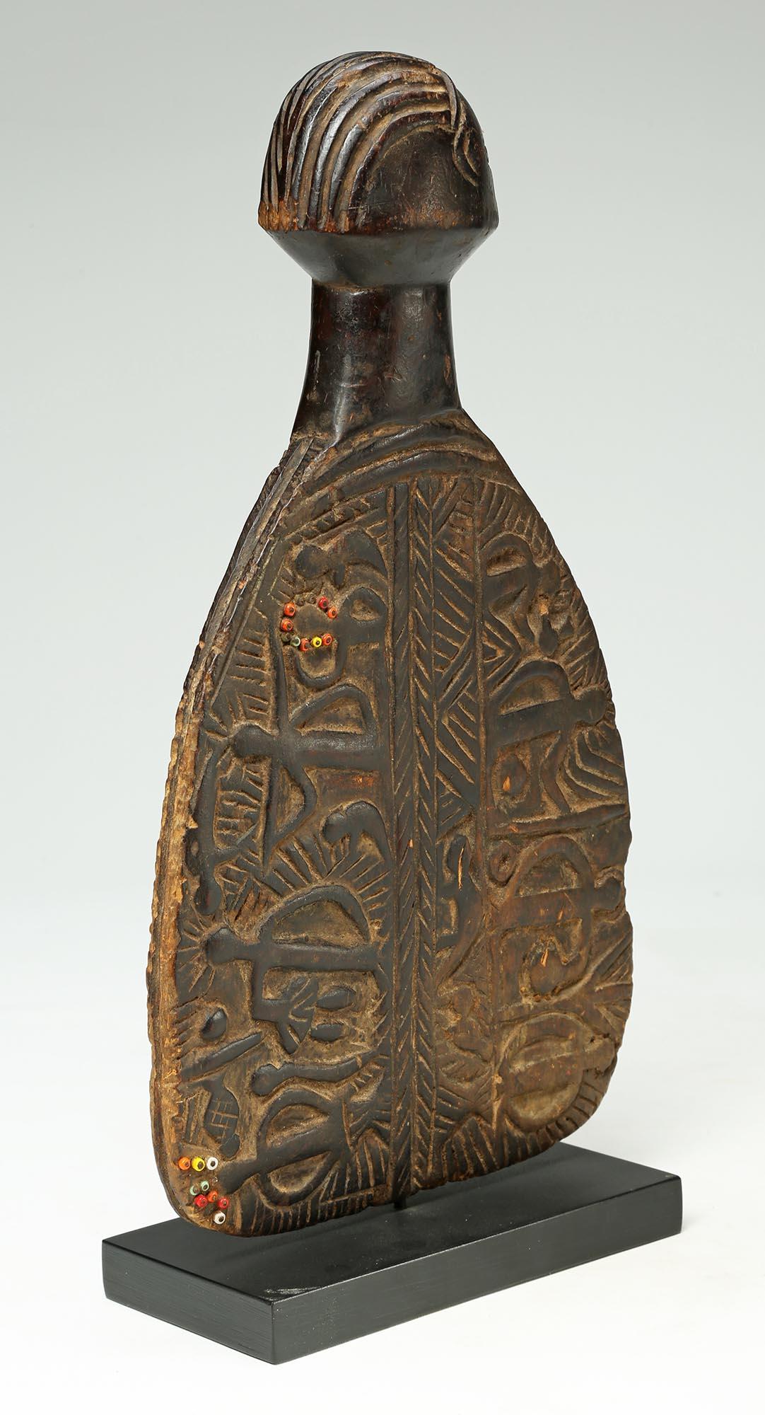 A rare finely carved Luba memory or story board in the shape of a carved paddle with inlaid bead circles on one side and raised figures. In good condition some wear to front of face and around rim. From the Democratic Republic of Congo, early to