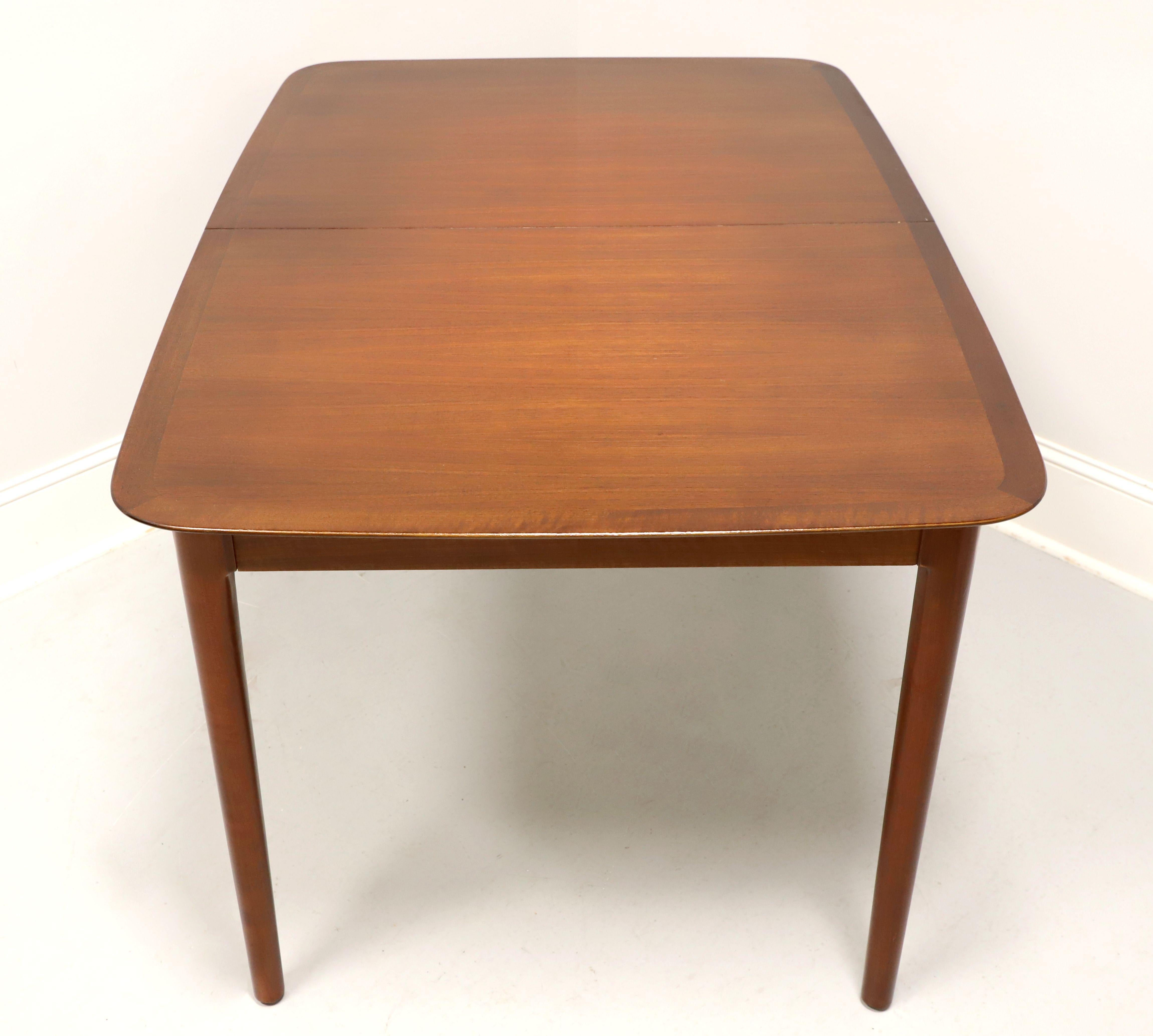 A rectangular shaped dining table in the Mid 20th Century Modern style by Lubke. Mahogany with banding & rounded edges to the top, smooth apron, pull out on ends supports for when leaves are in use, and tapered straight legs. Stored within the table