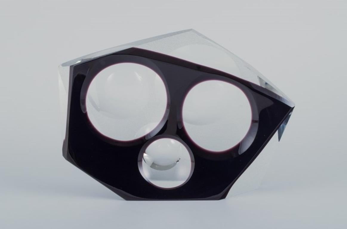 Lubos Metelak para Moser, artista checo del vidrio artístico. 
Escultura de cristal única diseñada en cristal transparente y esmerilado, con la parte frontal de color morado. Diseño abstracto con círculos.
Firmado y fechado en 1970 - con la marca