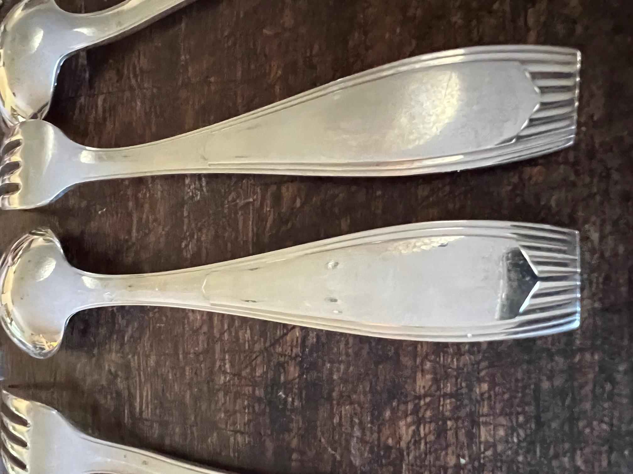 Art Deco style flatware in the Saigon pattern designed by Luc Lanel and made by Christofle around the 1950's in France.

Dinner Fork: 8 inches
Dinner Spoon: 8 inches

Each utensil is stamped with the Christofle hallmark used between 1935 & 1983,  as