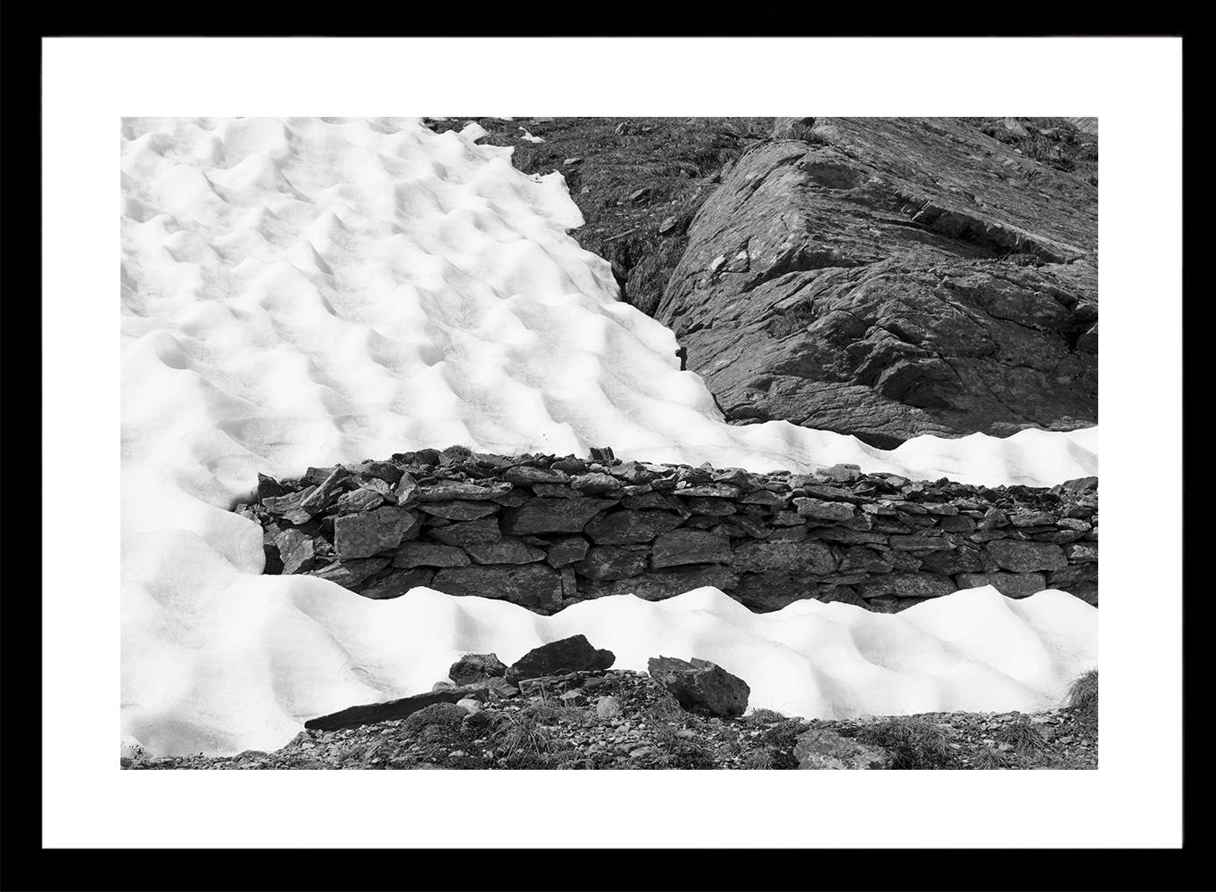 Luca Artioli Landscape Photograph - A Fatal Pass, War remains emerging from the snow. Black and White landscape