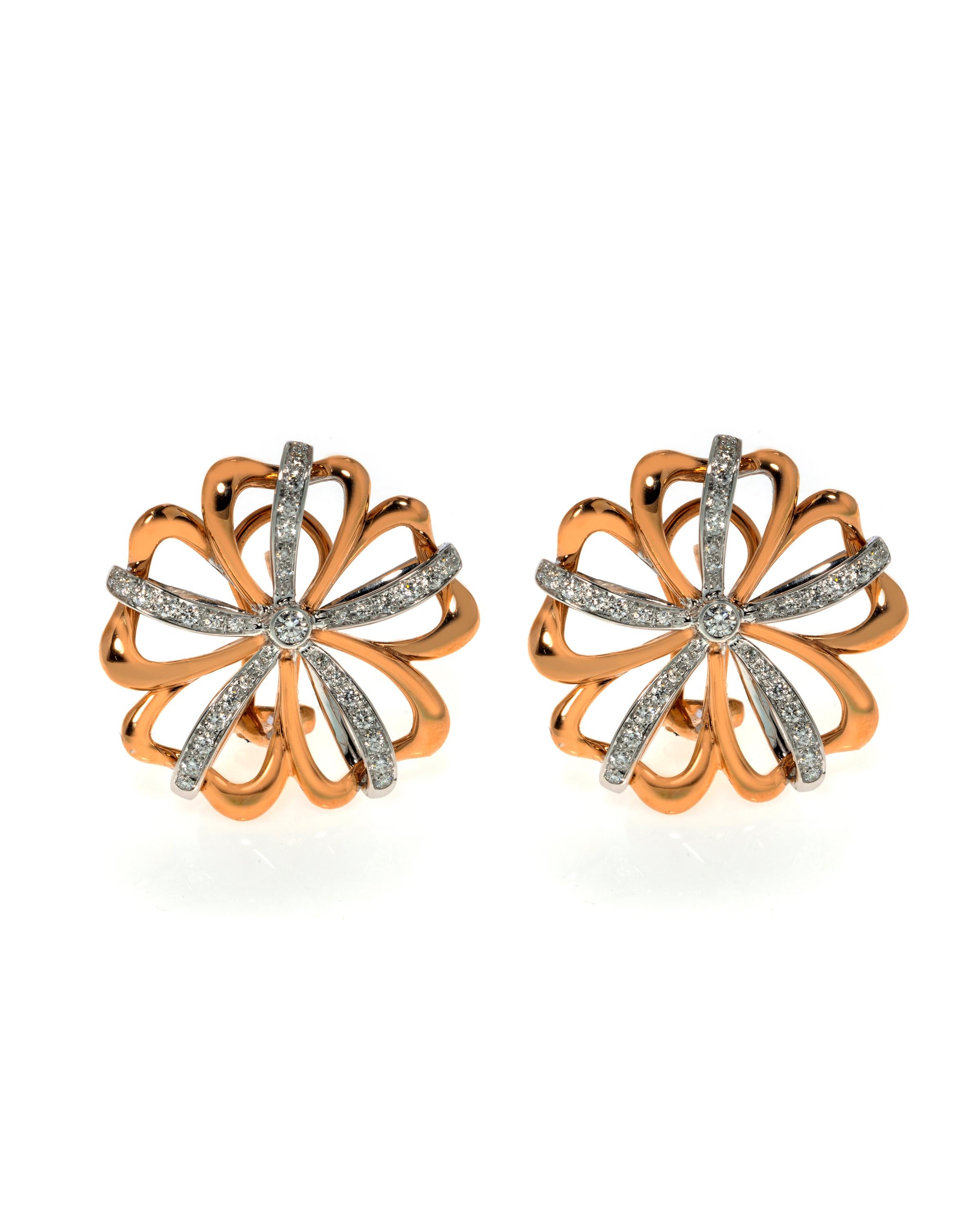 This gorgeous pair of estate earrings is finely crafted in solid 18k rose and white gold, made in the shape of beautiful flowers. The total diamond weight for the pair is 0.78 carats of VVS clarity and G color. Each earring measures 27mm. The