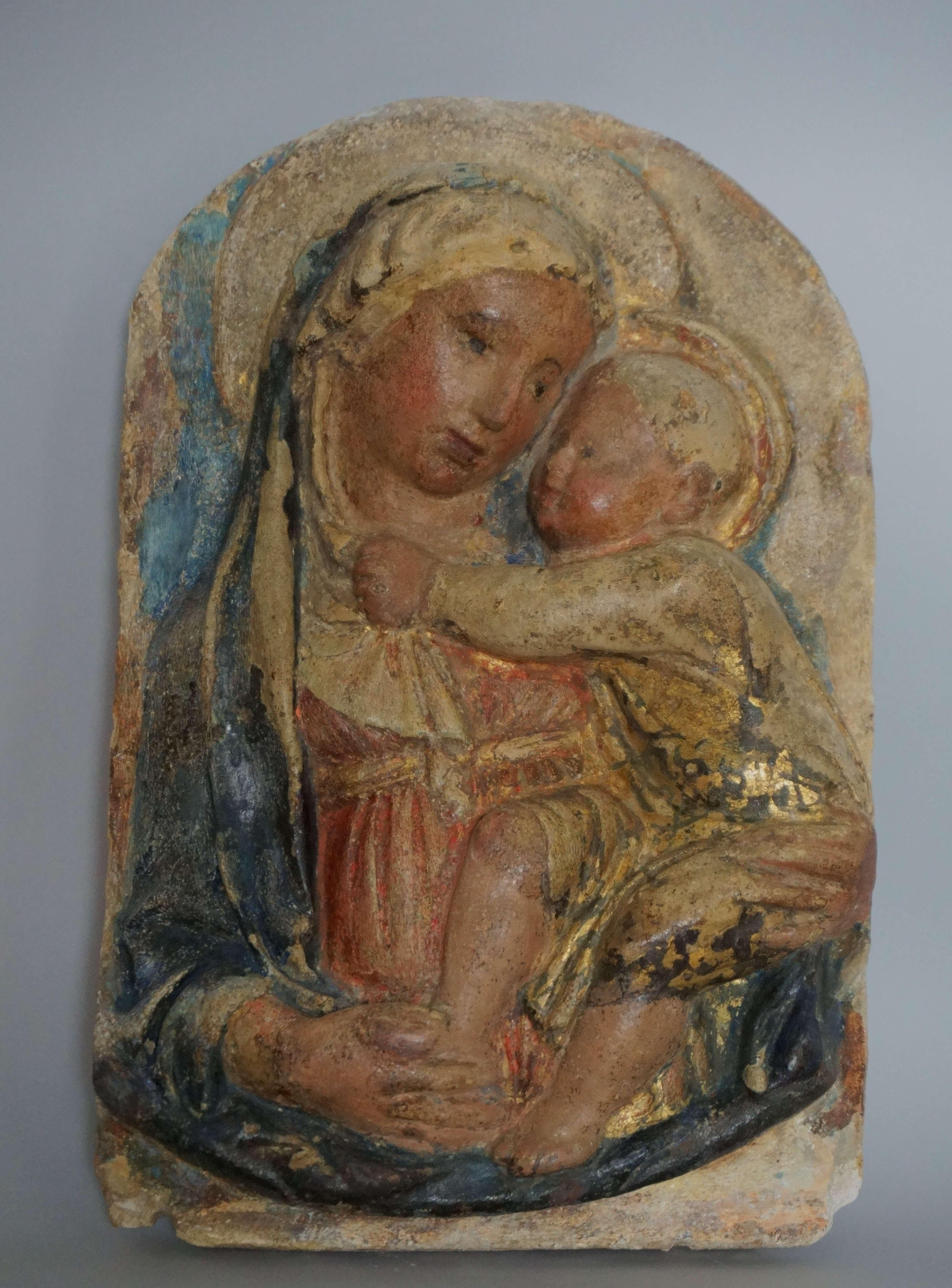 Virgen con el Niño, relieve en estuco policromado, taller de Luca della Robbia. Segunda mitad del siglo XV.
Modelado de medio cuerpo, el Niño sostiene el velo de su madre en una mano, la otra en la espalda, la Virgen le agarra el pie.
Esta