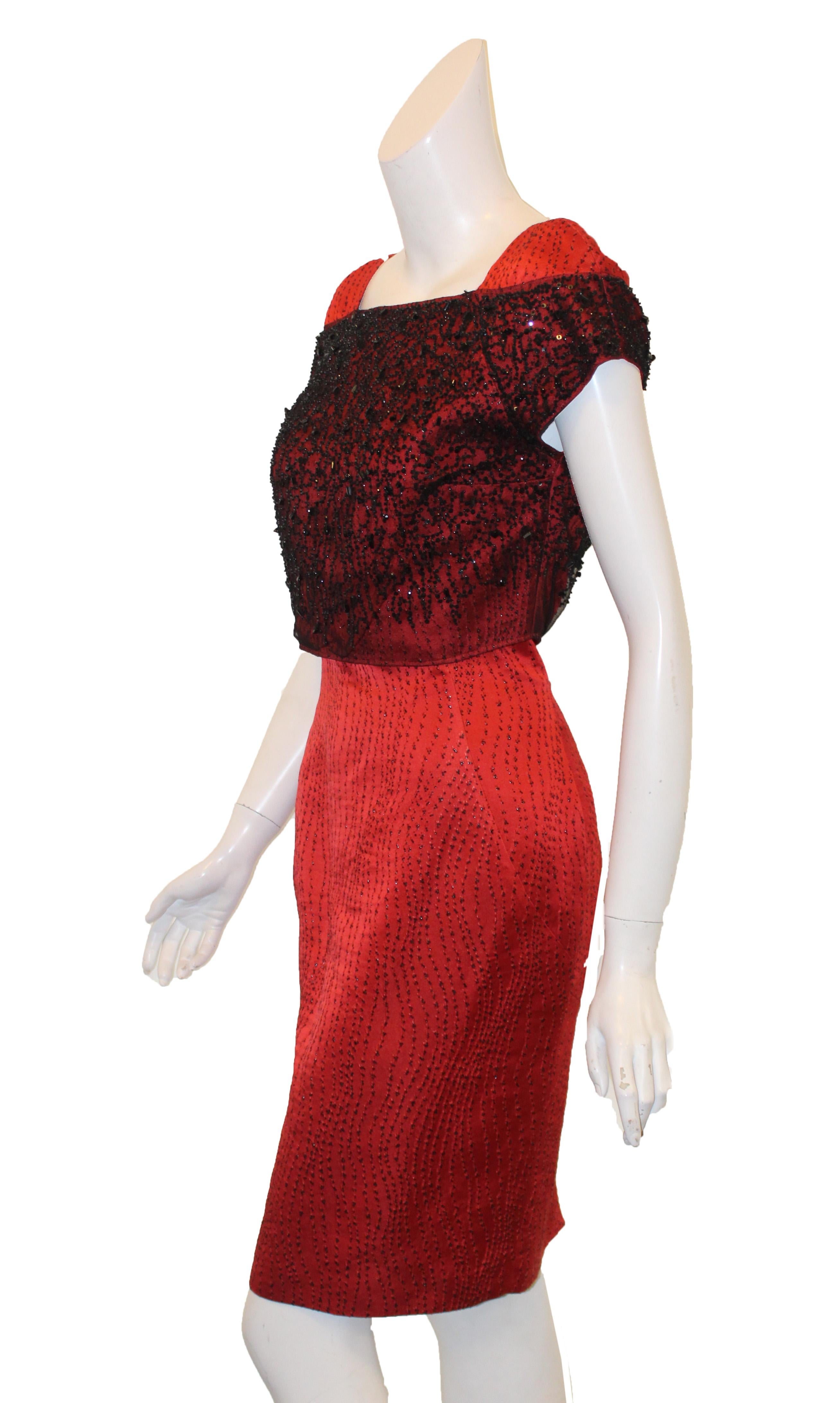 Luca Luca red and black two piece dress ensemble includes a sequined beaded bolero jacket and a strapless dress.  The fabric design on the dress are vertical embroidered threads in red and black cascading down the dress.  The bolero jacket has a
