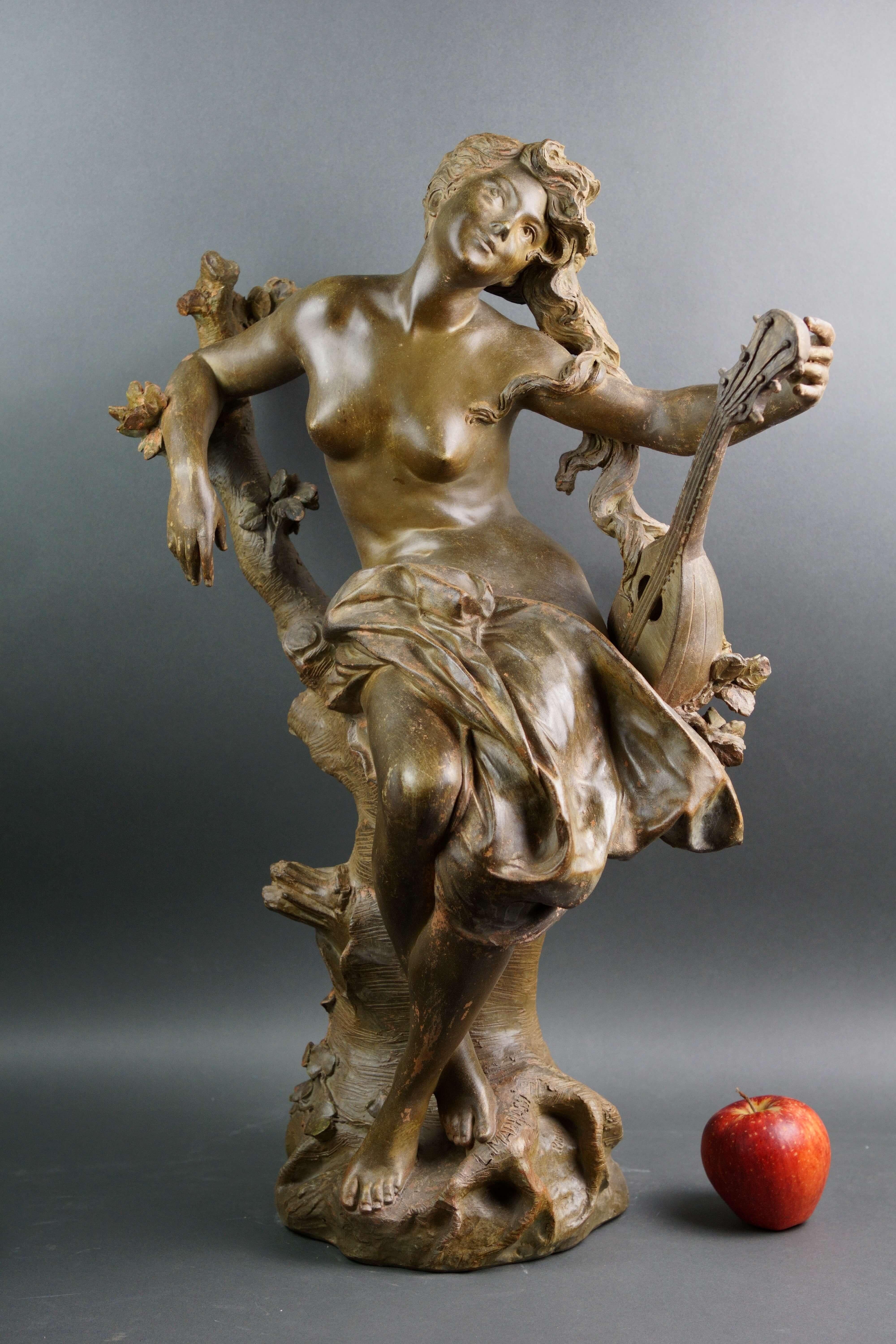 Luca Madrassi (1848-1919), gran escultura de terracota patinada de estilo Art Nouveau, finales del siglo XIX.  La escultura representa a una joven semidesnuda sentada en un árbol con una mandolina en la mano izquierda.  Está firmado L.