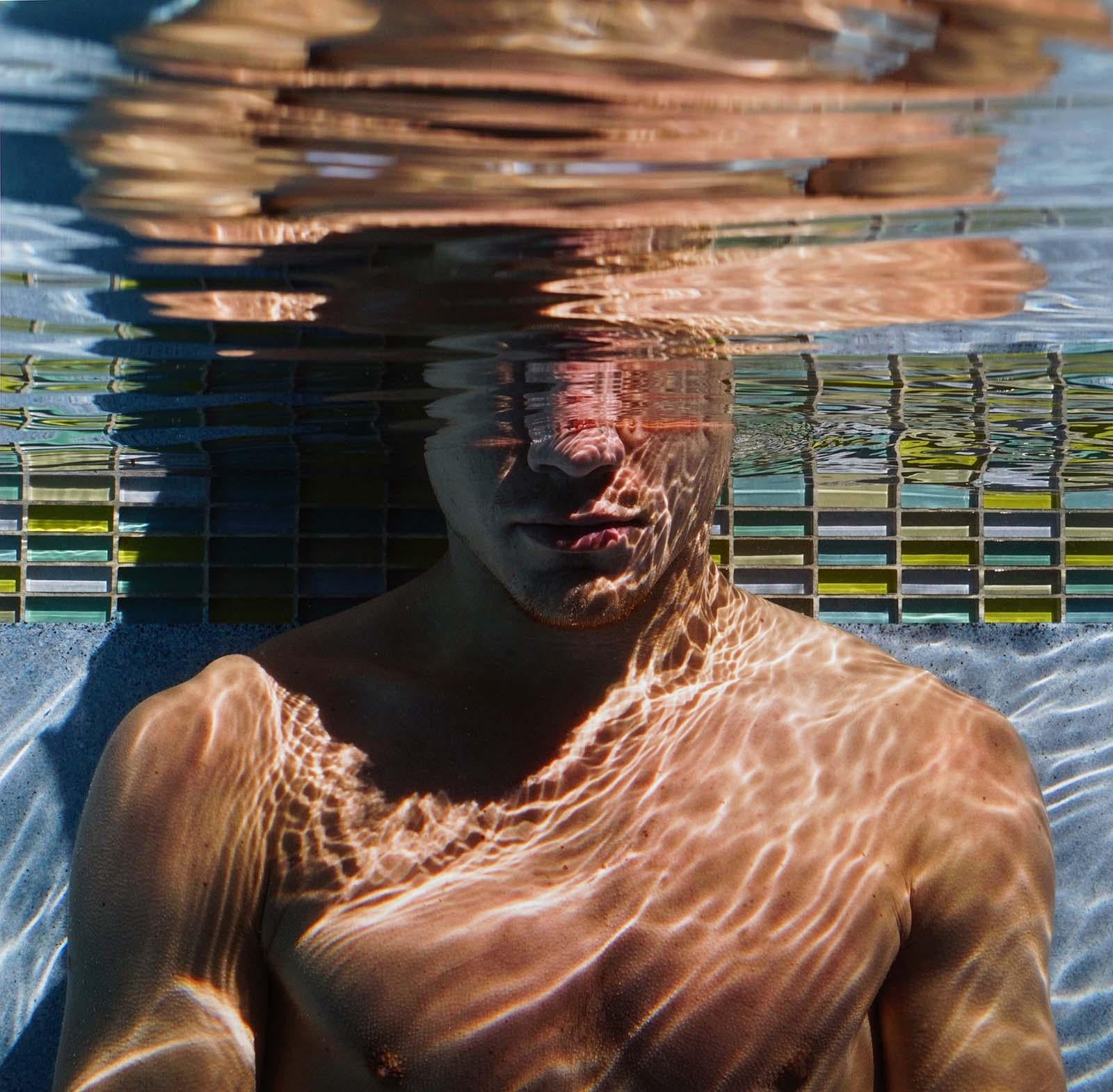 Lucas Murnaghan Figurative Photograph - Mind Over Matter (Young male diver tests breath control in sun splashed  pool)