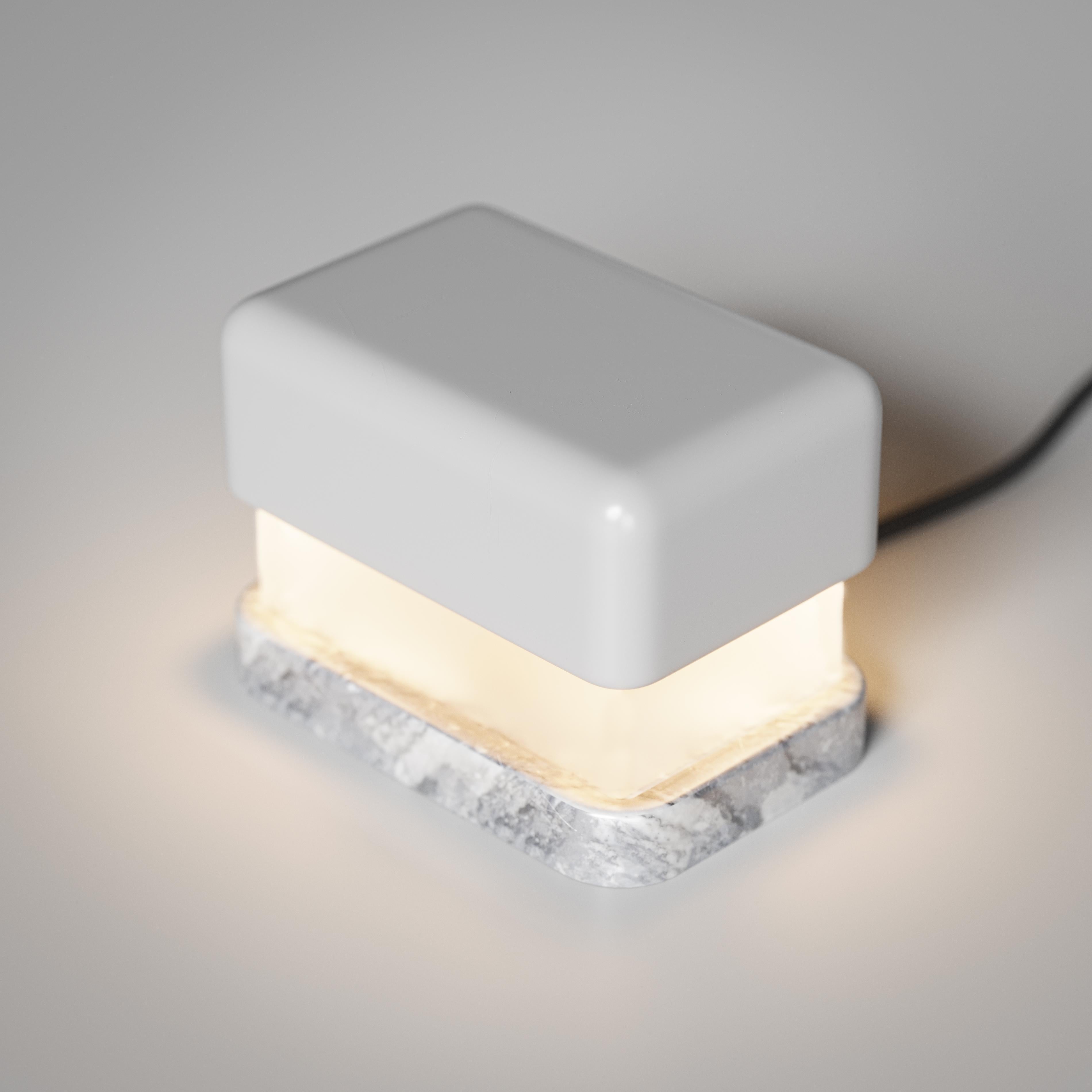 Kleine Tischlampe. Obere Kappe aus mattgrau lackiertem Holz; Diffusor aus mattiertem Glas. Sockel aus Bardiglio-Marmor. Graues satiniertes Kabel.
Entworfen von Matteo Bianchi für Officina Luce.

1 x LED-Modul mit Transformator, alles inklusive. 