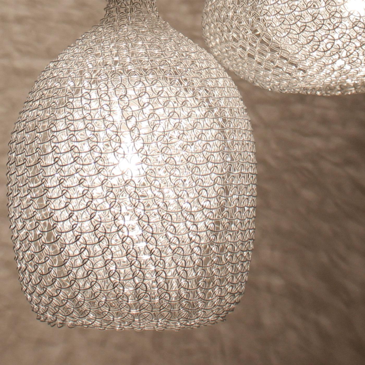 Suspended from the ceiling with a copper-finished metal cap, this unique pendant lamp is crafted by minutely hand-weaving, both inside and outside, a single copper thread coated with a double layer of resin in a delicate pearl-gray hue. Generating a