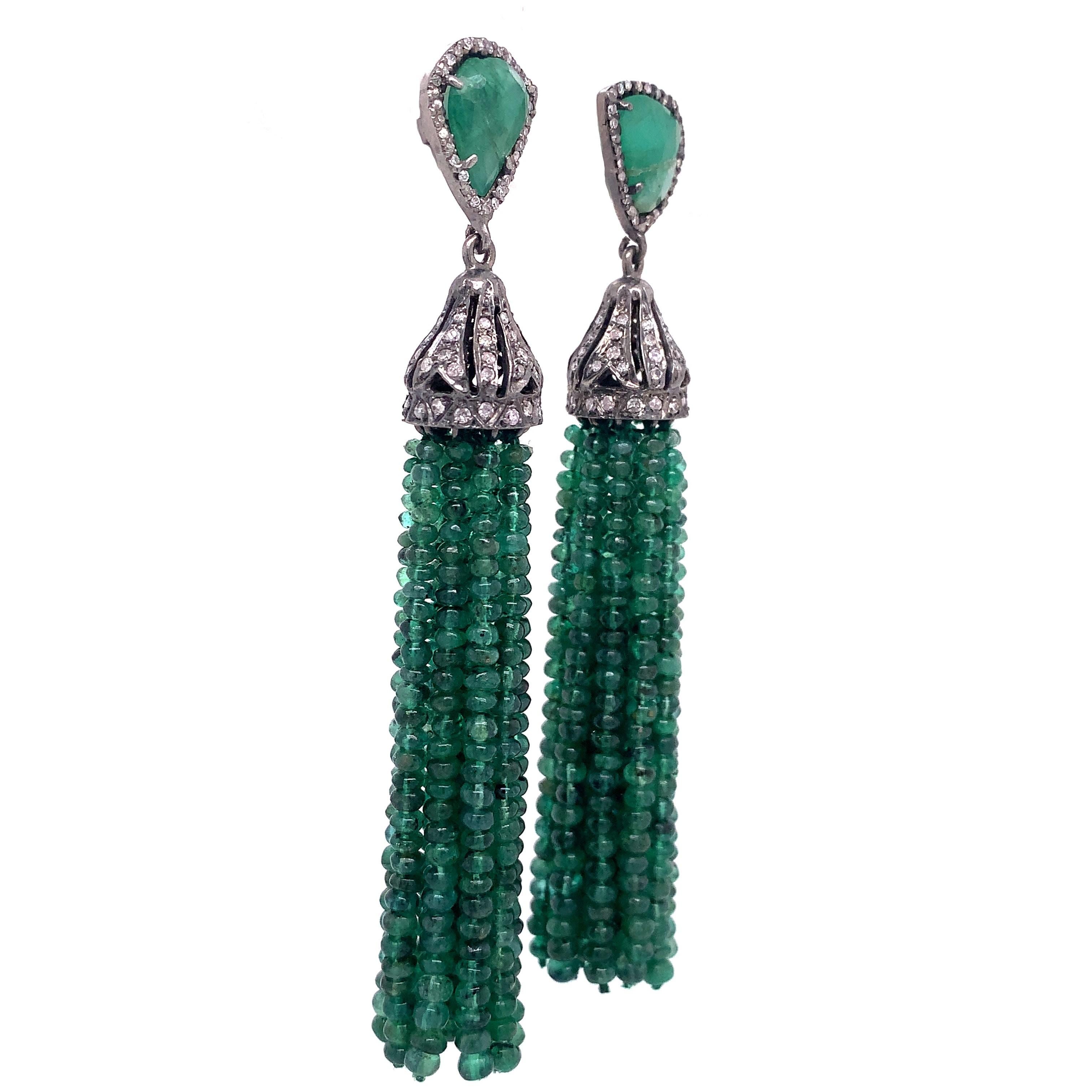 Life in color Collection

Natural Emerald Slice wrapped in diamonds and featured Emerald tassel beads dangling from a crown cup set in blackened Sterling Silver.

Emerald: 12.24ct total weight.
Diamond: 0.81ct total weight.