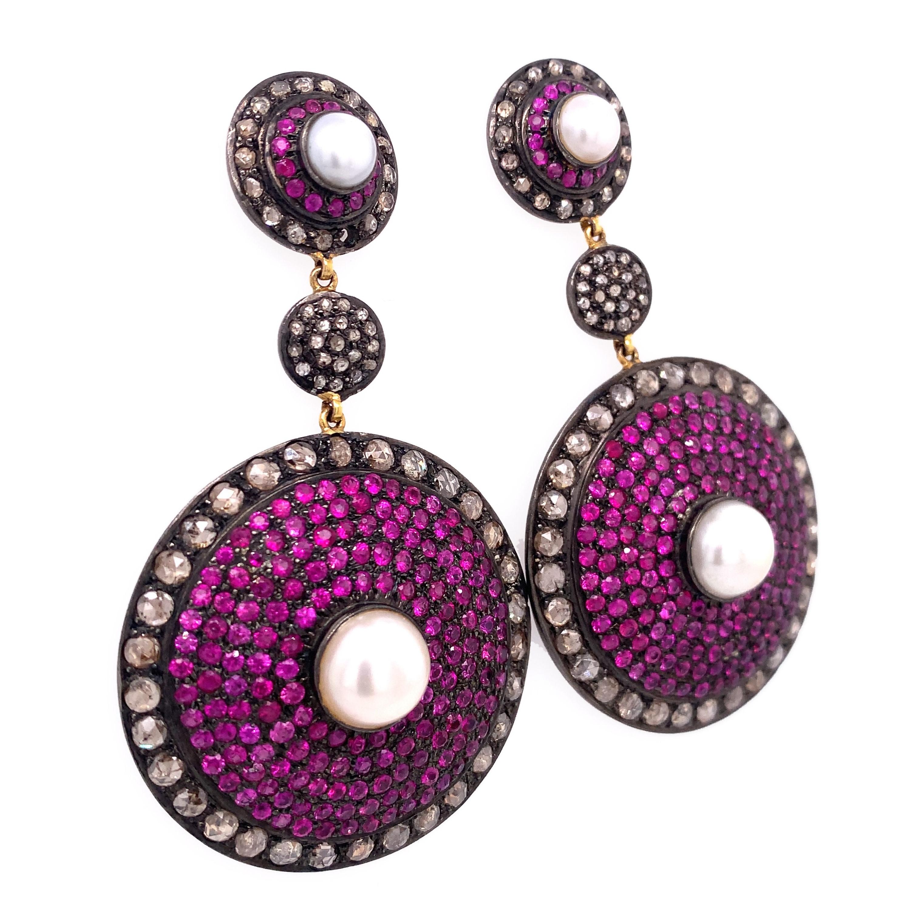 Life in Color Collection

Pearls, Rubies with icy Diamonds drop earring set in blackened Sterling Silver and 14 k yellow Gold plated. Approximately 6 mm and 9 mm Pearls.

Ruby: 7.07ct total weight.