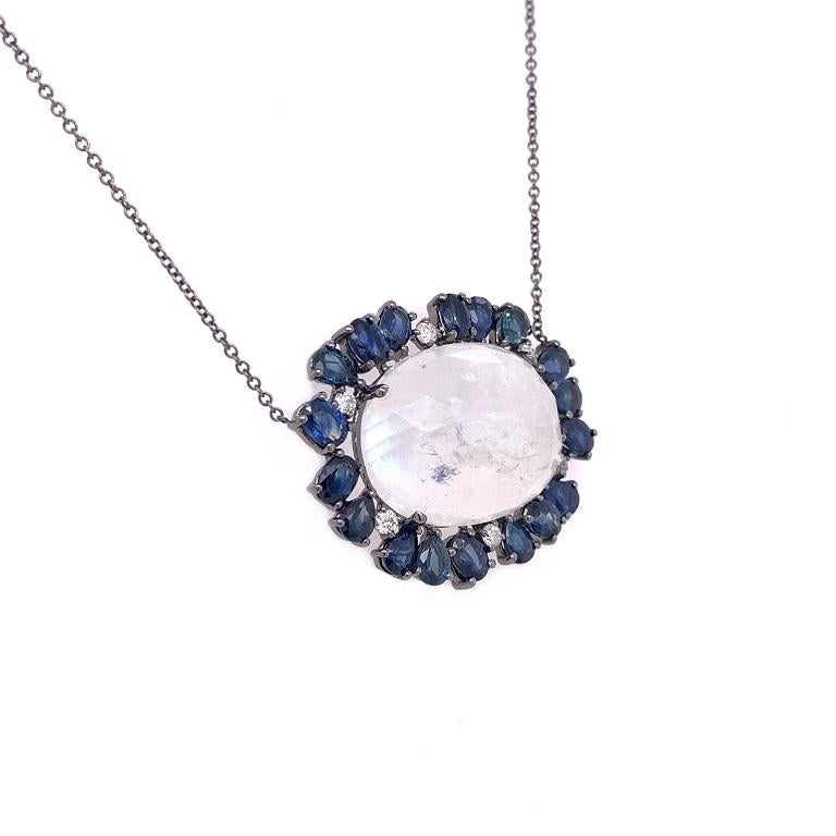 Blue Dream Collection

Rose cut rainbow Moonstone with blue Sapphire and Diamond halo set in solid 18K black rhodium gold. Chain is adjustable. 

Moonstone: 13.40ct total weight. 
Blue Sapphire: 4.28ct total weight.
Diamonds: 0.14ct total weight. 
