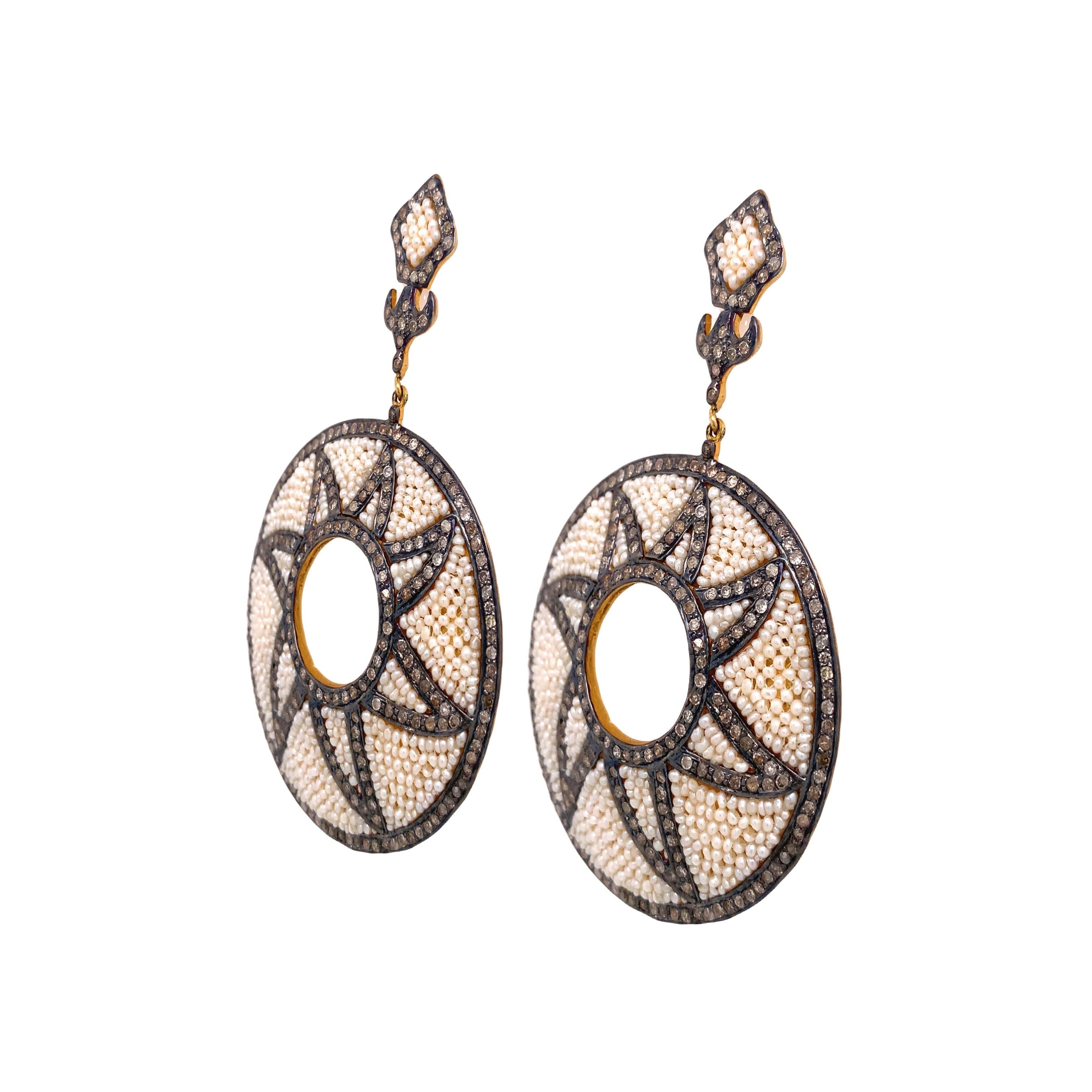 Collection
This pair of earrings is a match made in heaven with its elegant design and its icy diamond and seed pearl combination. The earrings are made with a 14K yellow gold plated Sterling Silver setting with a disc-shaped design.

Diamond: