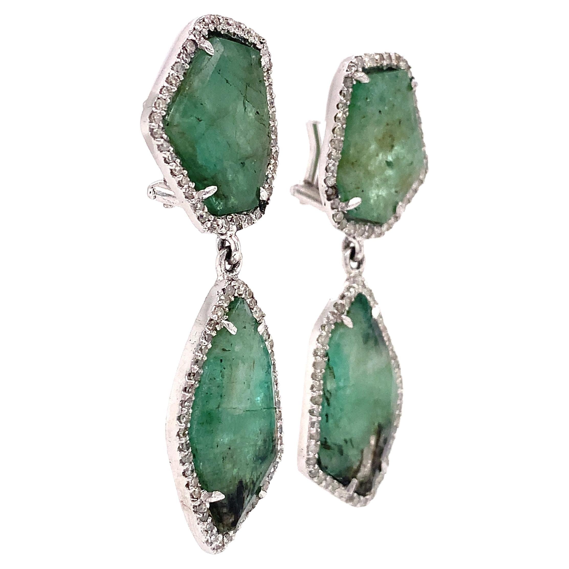 Natural Emerald slices wrapped in Diamonds.  

Emeralds: 23.50ct total weight.
Diamonds: 0.89ct total weight.