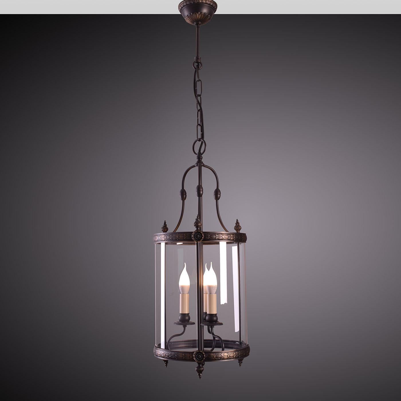 Minutely chiseled and offered in a precious antiqued bronze-veil finish, this pendant lantern is an apt member of the Lucerna Collection of designs of unmistakable classic inspiration. Black fabric cables complete the elegant structure, equipped