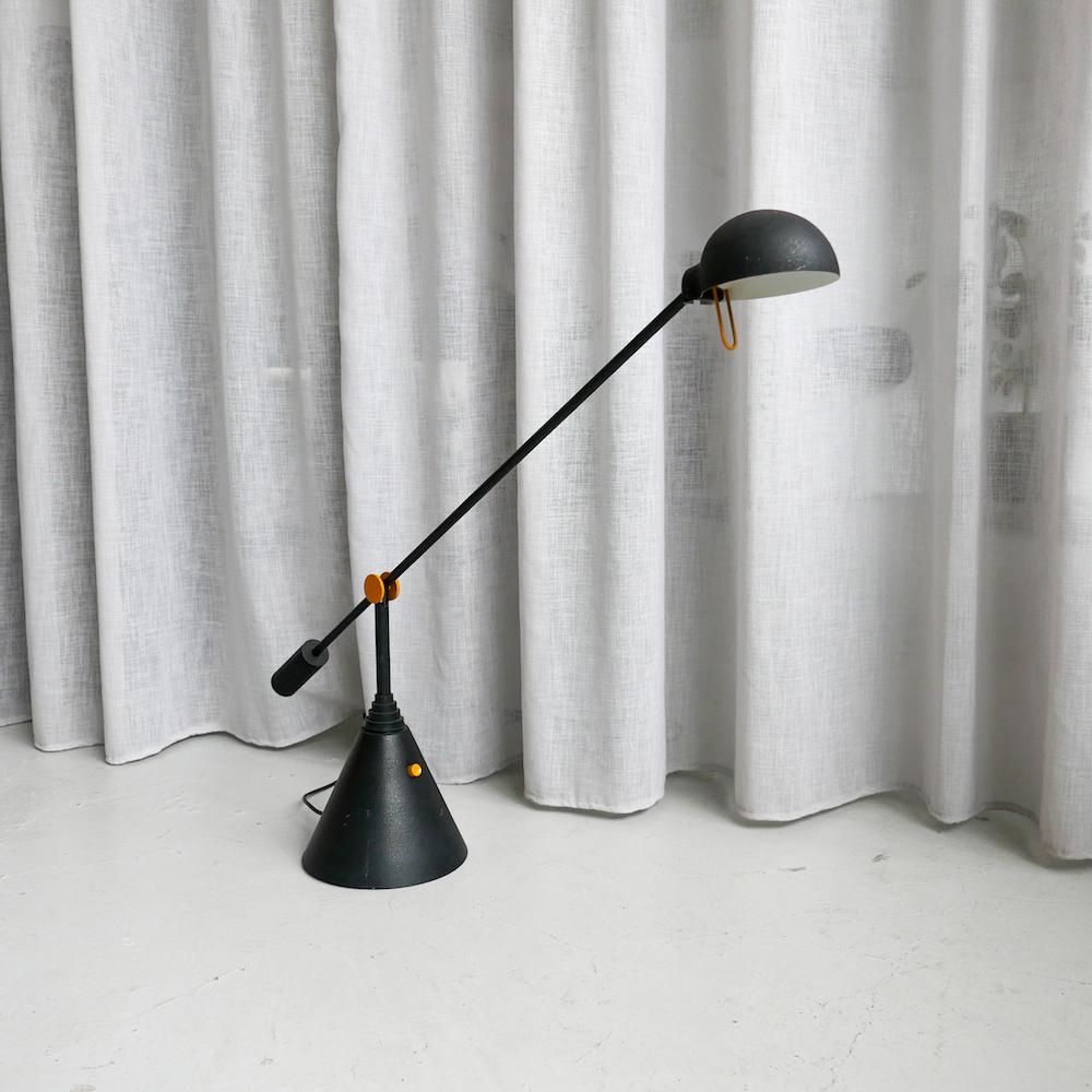 Memphis Style Lamp - 1980s Pop Design - Decorative Table Lamp

Vintage 1980s table lamp by Luci Milano, with a cone-shaped base and a slender adjustable arm. Finished in black, it has bright yellow details that add  touch of colour and perfectly