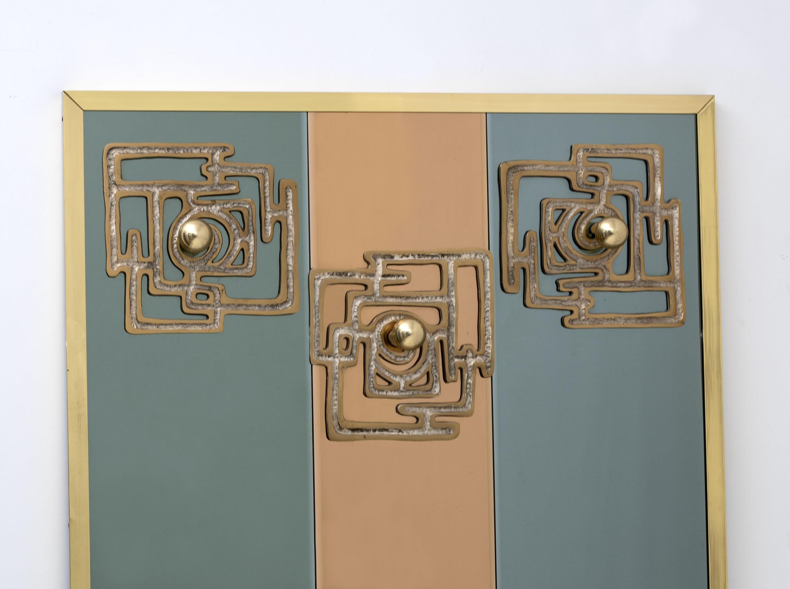 Designed by Luciano Frigerio this delightful and unique mirrored coat hanger, divided into three mirror parts in rose gold and gray colored with 3 sculptural bronze plaques applied with brass spheres.