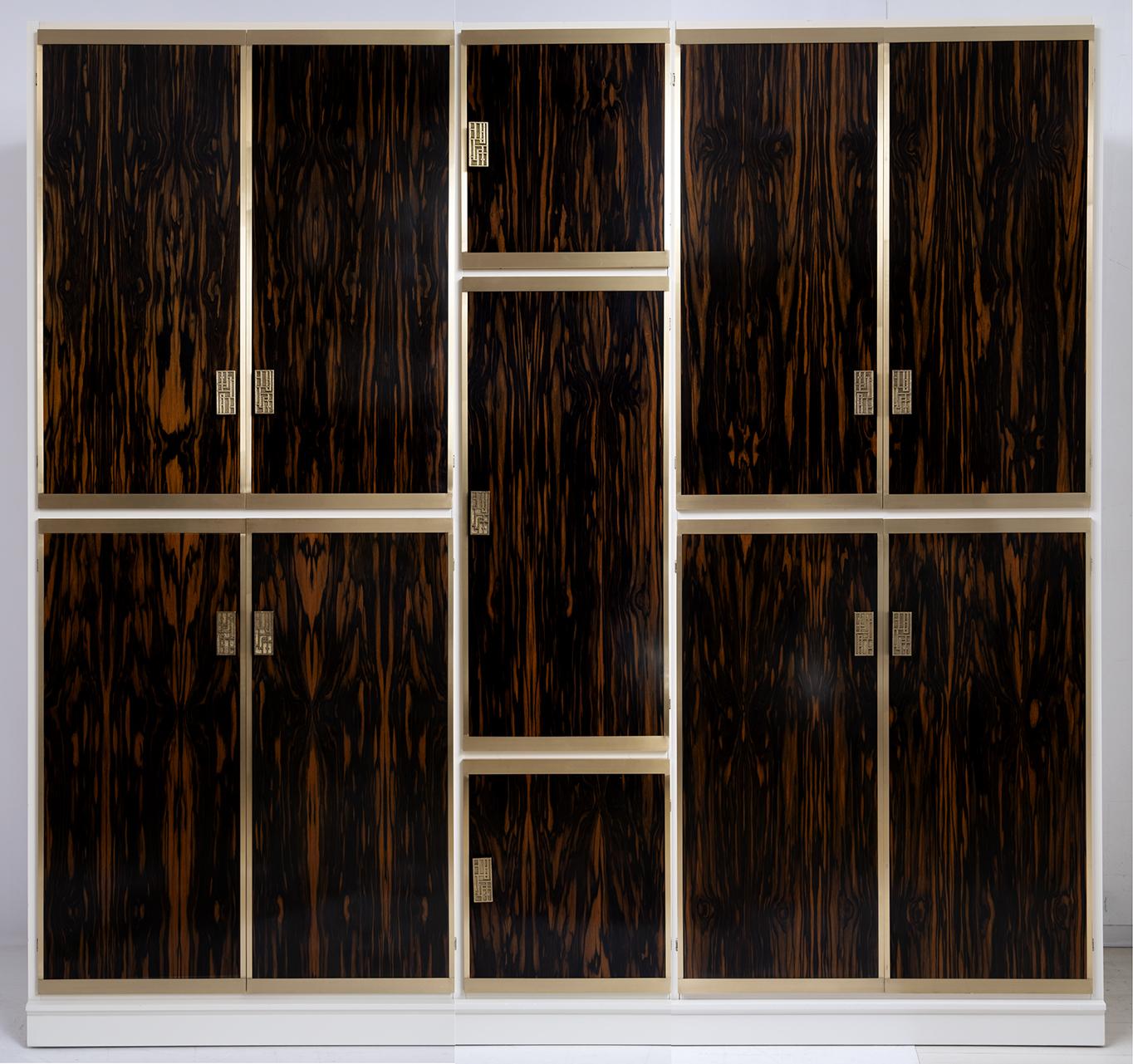 Designed by Luciano Frigerio, wardrobe with eleven doors in brass and walnut wood, Macassar ebony is a precious essence that is widely used in cabinet making, fine carpentry, turning and in the manufacture of musical instruments. Due to its merits,