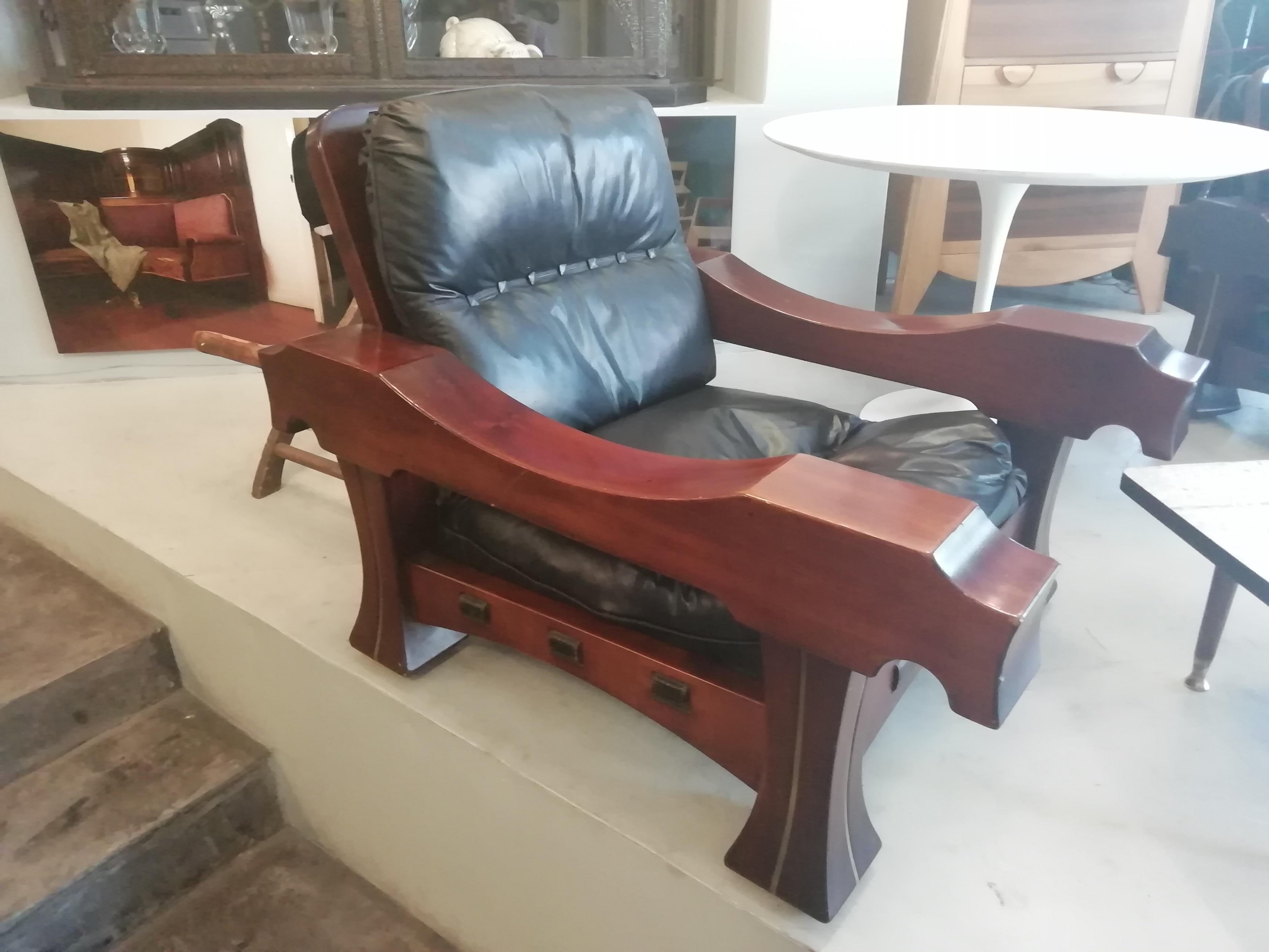 Massive pair of Italian Mid-Century Modern mahogany and black leather Ussaro armchairs by Luciano Frigerio. The mahogany structure has brass details on the legs.