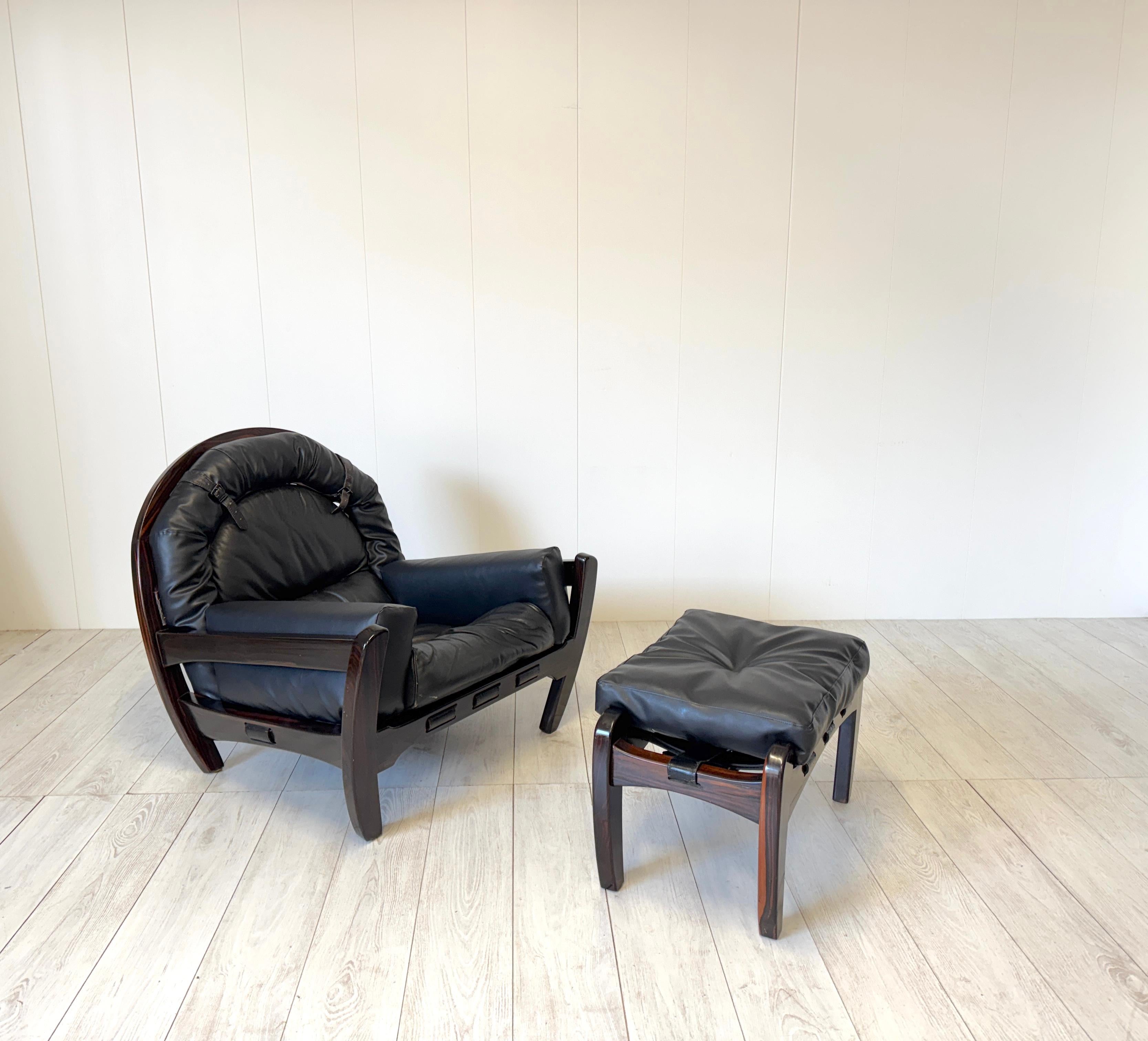Raro e importante sillón con puf firmado Luciano Frigerio de madera de caoba mod. Rancero, producción Frigerio, Desio, años 70. El armazón de madera de caoba está provisto de correas de cuero negro y cojines de cuero negro.
