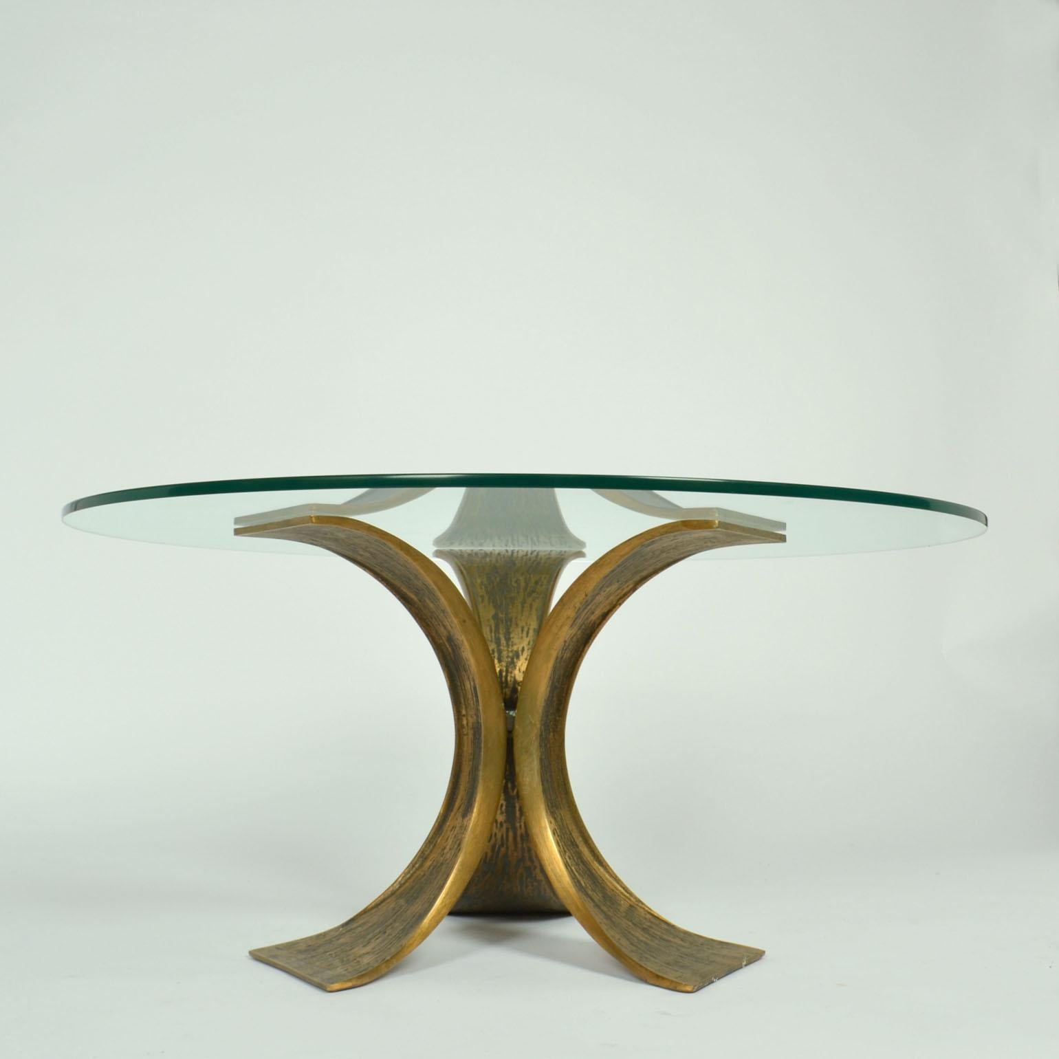 Sculptural winged bronze round table with glass top by Luciano Frigeriom born in Desio in 1928..
The table base is made of three bronze butterfly shaped arms are connected together in a hexagonal center. Their wings anchor to the ground.