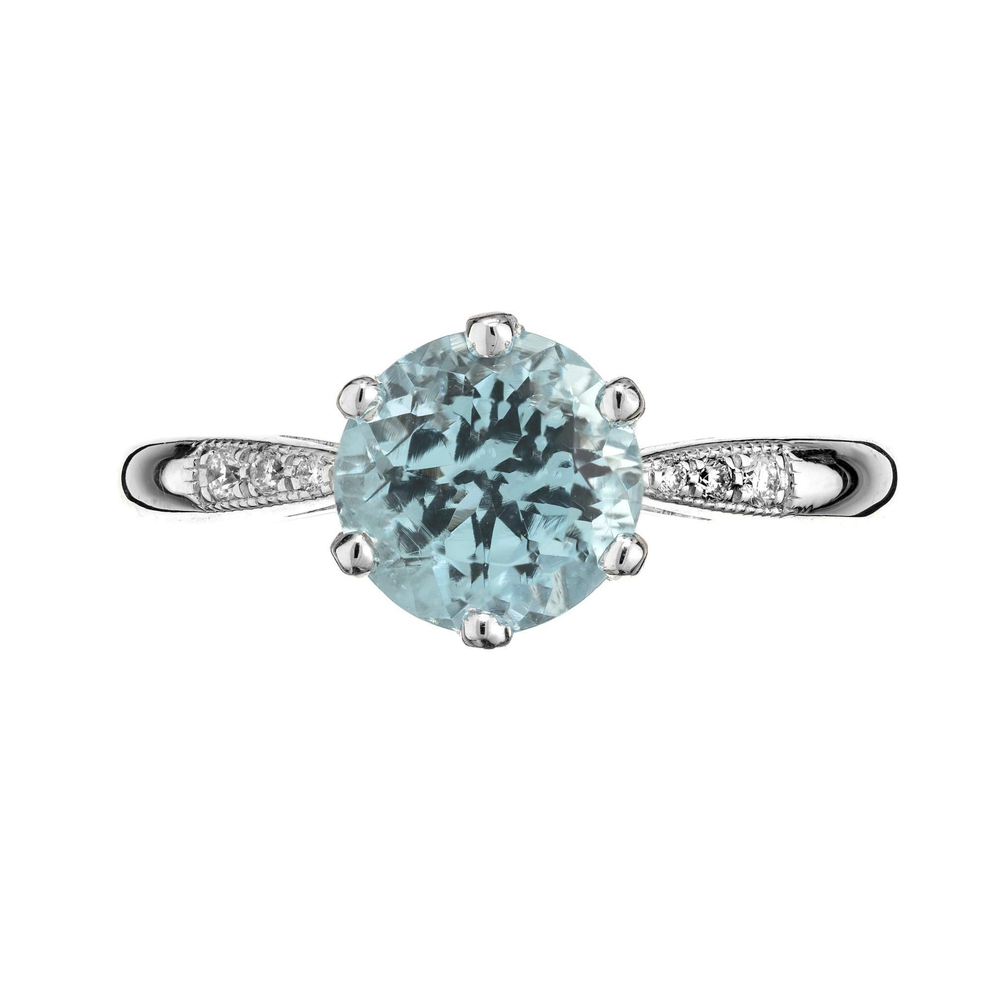 Lucie Campbell London Aqua and Diamond platinum engagement ring. This exquisite piece graces the hand with a mesmerizing 1.34ct round aquamarine center stone accented by three round brilliant cut diamonds on each shoulder of the shank. Crafted in
