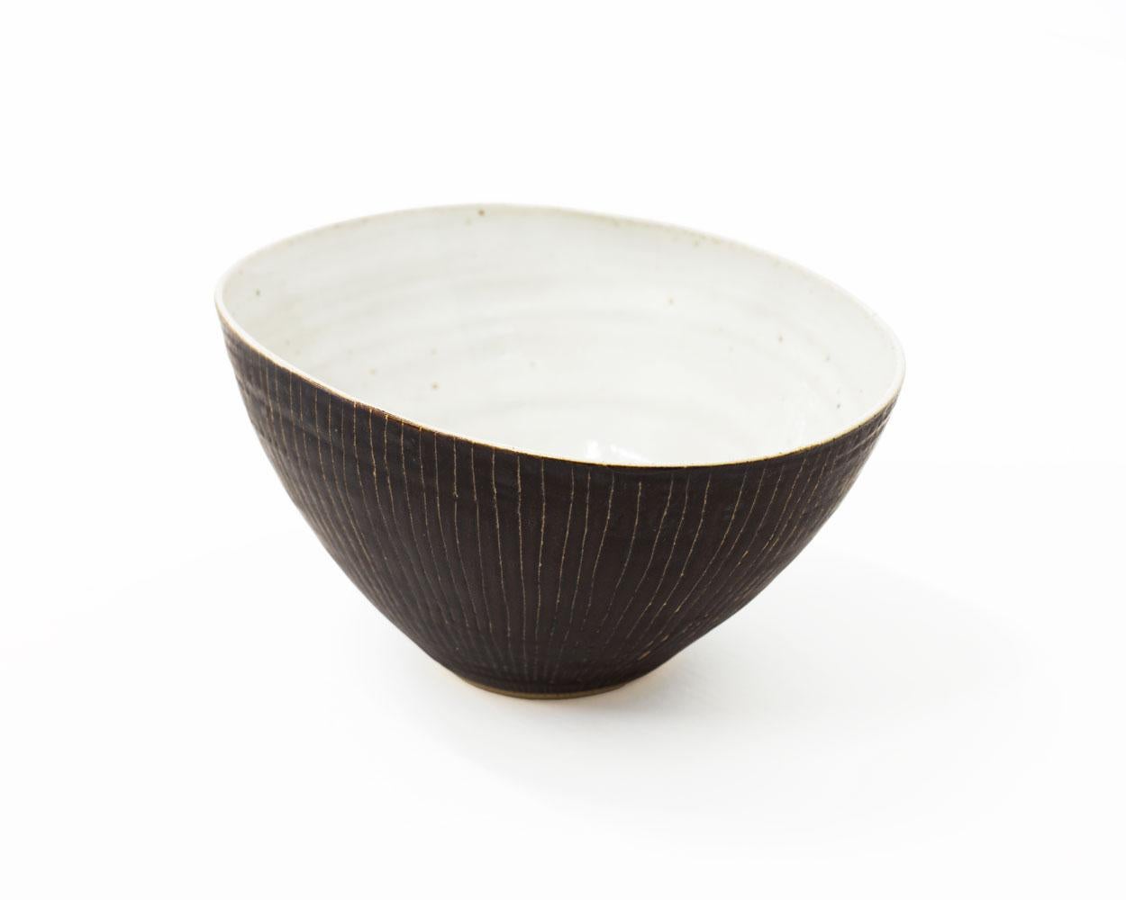 Impression du sceau de l'artiste
Porcelaine, avec glaçure manganèse et décor sgraffite, et glaçure blanche piquée.
3 x 6.25 pouces
