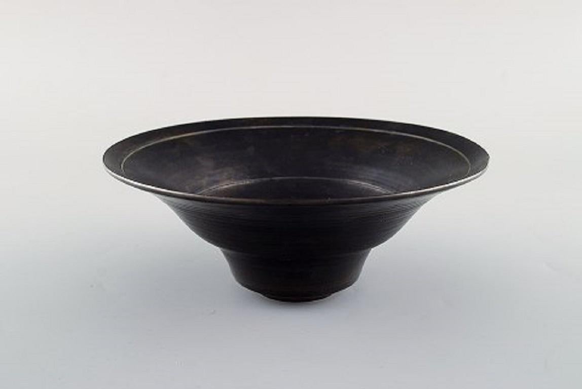 Lucie Rie (b. 1902, d. 1995) Austrian-born British ceramist. Stylish bowl in black glazed ceramics. Own workshop, circa 1970.
Measures: 18 x 7 cm.
Signed: LR in monogram.
In very good condition.

Lucy Rie’s works, usually consisting of