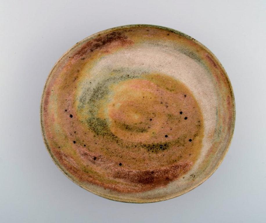Lucie Rie (b. 1902, d. 1995), Austrian-born British ceramist. 
Large modernist bowl in glazed stoneware. 
Beautiful glaze in light earth tones. 
Own workshop, approx. 1970.
Measures: 28 x 24 x 8 cm.
In excellent condition.
Signed: LR in
