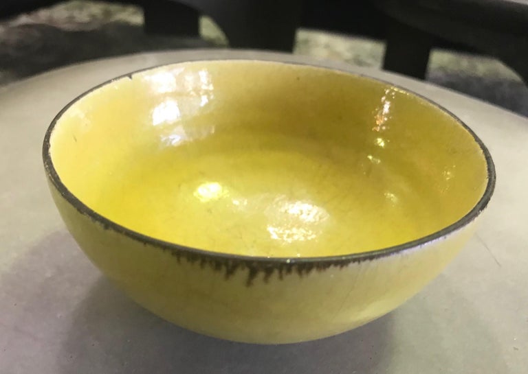 A gorgeous mustard-yellow glazed stoneware bowl with manganese rim by famed European potters Lucie Rie & Hans Coper.

The bowl is signed with each artist's impressed seals on the base.

Simply a must for any collector of Rie or Coper's work or a