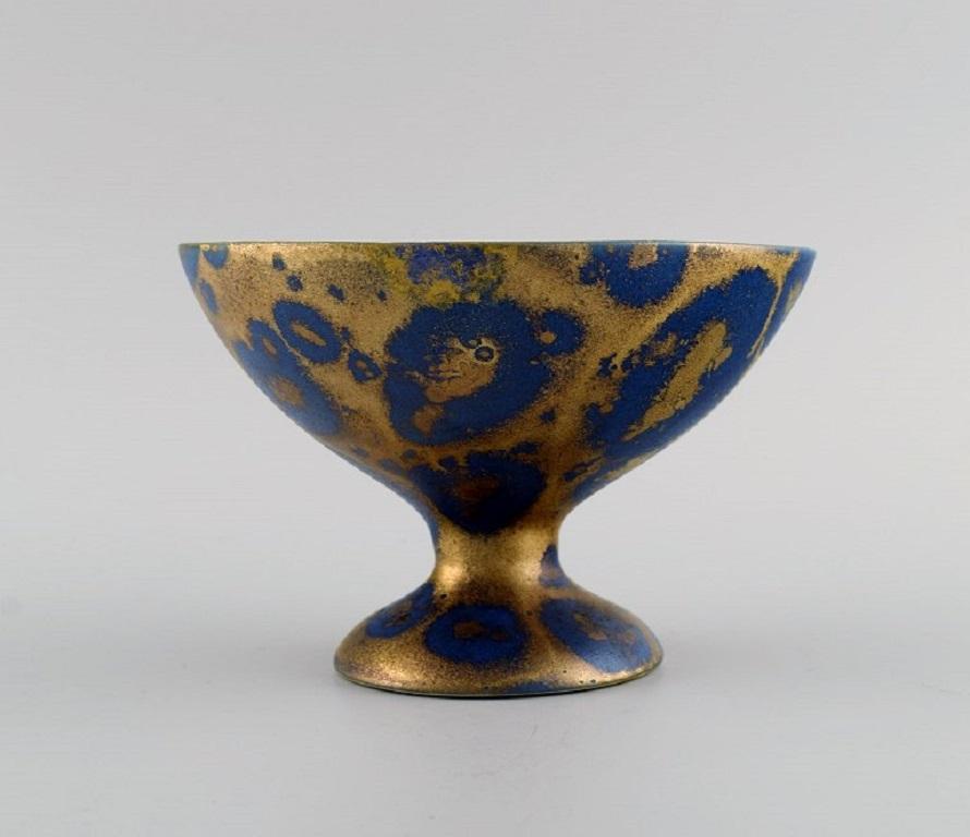 Lucien Brisdoux (1878-1963), France. 
Bowl on foot in glazed stoneware. Beautiful glaze in gold and blue shades. 
1930s / 40s.
Measures: 14 x 9.5 cm.
In excellent condition.
Signed.