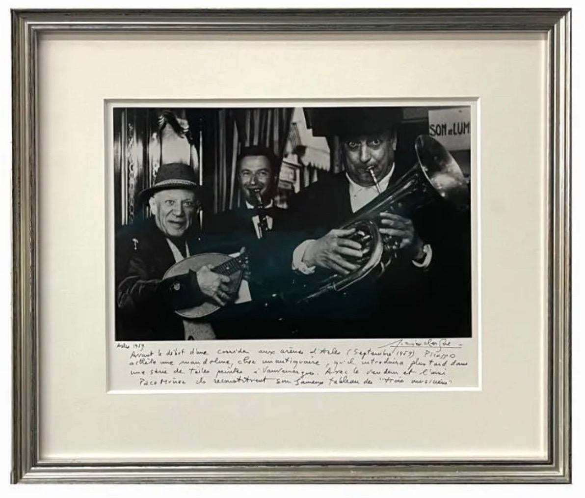 Lucien Clergue (FRENCH, 1934 - 2014) 
Gelatin silver photographic print depicting Pablo Picasso, Arles, 1959.
Picasso, l'antiquaire et Paco Munoz (les trois musiciens), Arles
A jazz or gypsy trio.
Hand signed by the artist with hand written