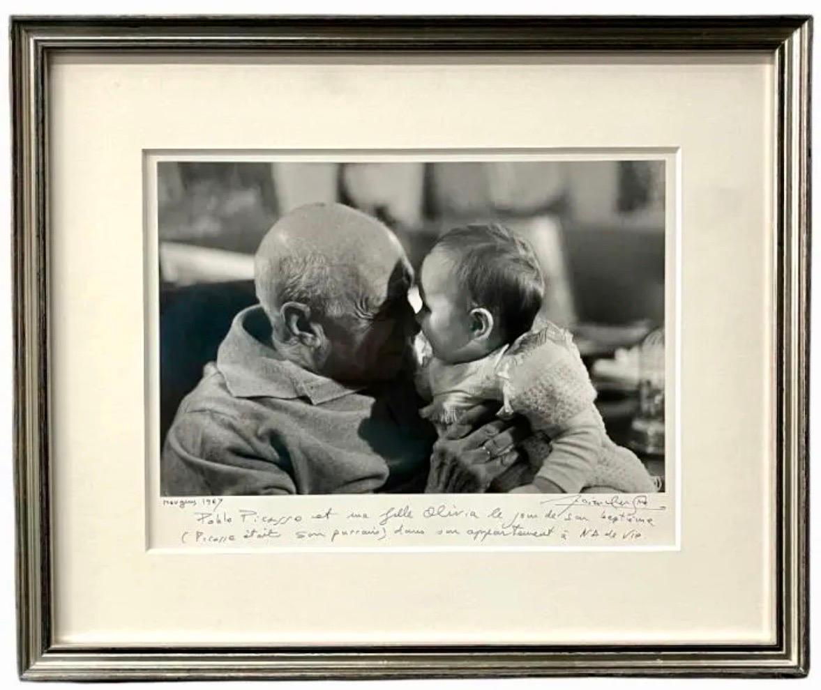 Lucien Clergue (FRENCH, 1934 - 2014) 
Gelatin silver photographic print depicting Pablo Picasso holding a baby.
Picasso et sa filleule Olivia (Picasso et bébé)
Mougins, 1967
Hand signed by the artist with hand written description. Titled and dated