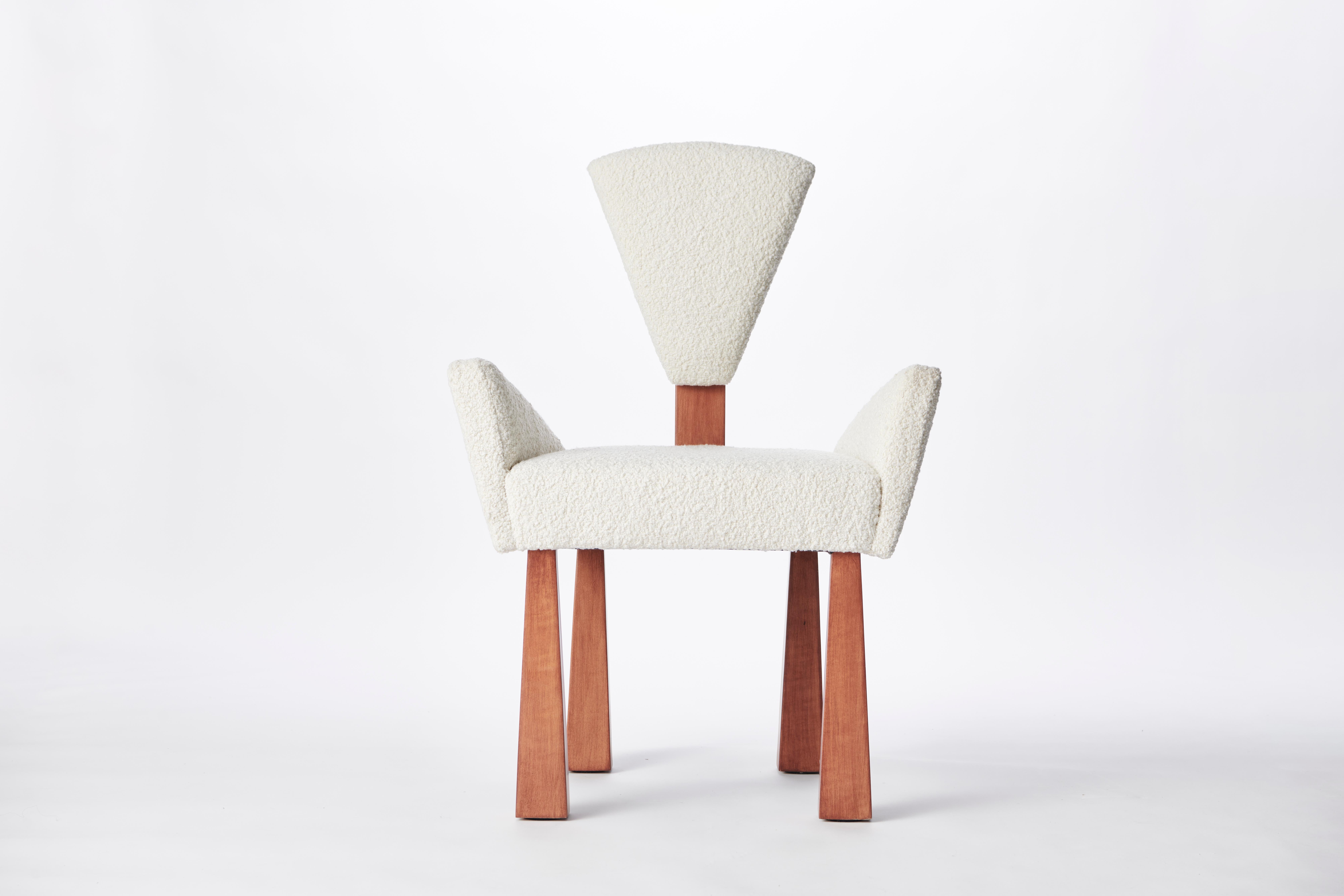 Made to order wood & bouclé dining chair designed by Christian Siriano.

Fabric: Ivory Bouclé (available in custom fabric)
Base: Red Oak Wood (available in custom finish)

Dimensions: 
Overall Depth: 21”
Overall Width: 25.5”
Overall Height: 37”
Back