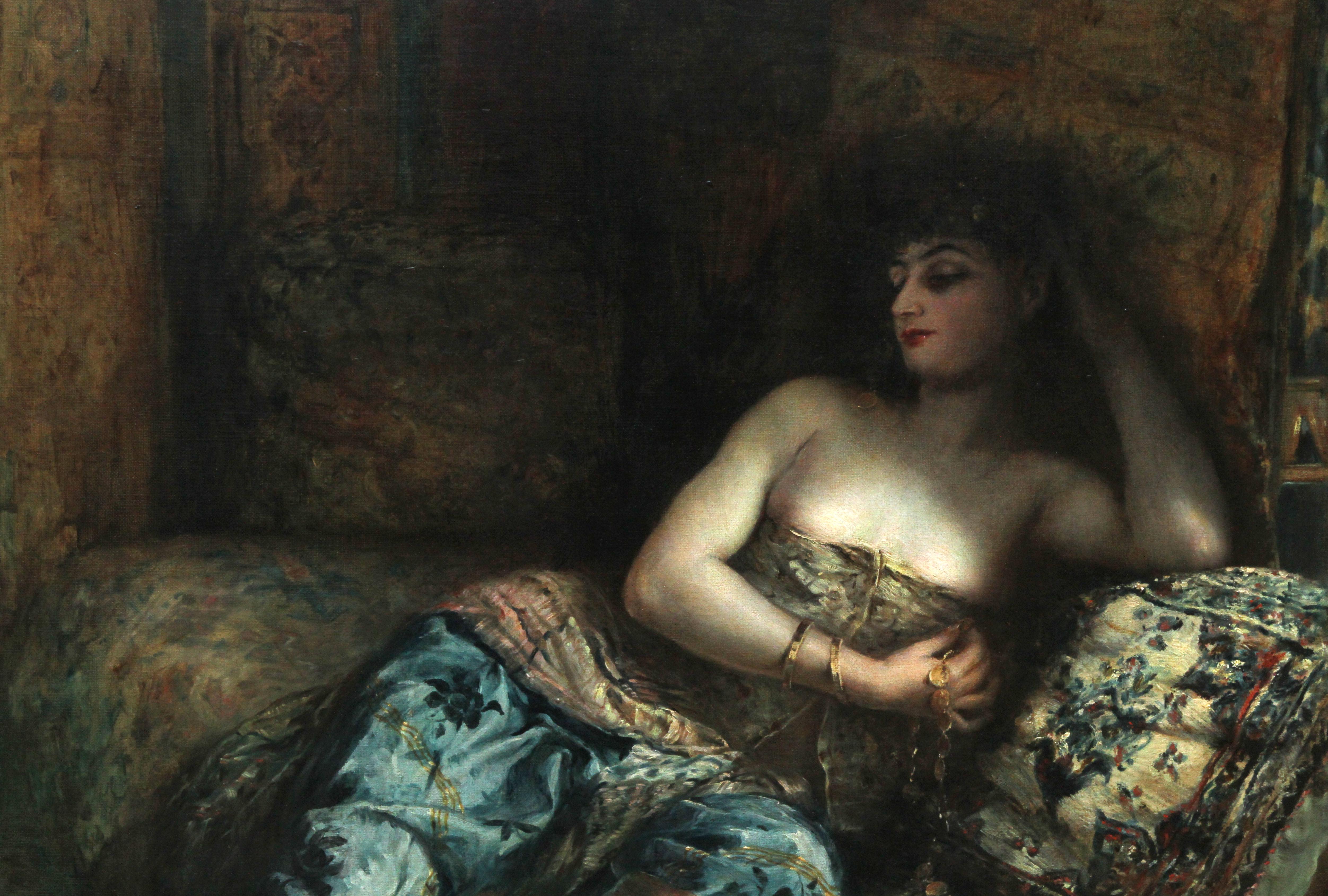 This charming ex Christie's Victorian Orientalist oil painting is by noted French exhibited artist Lucien Laurent Gsell. The painting dates to around 1900 and portrays a beautiful young woman reclining on a couch. The painting is entitled in French