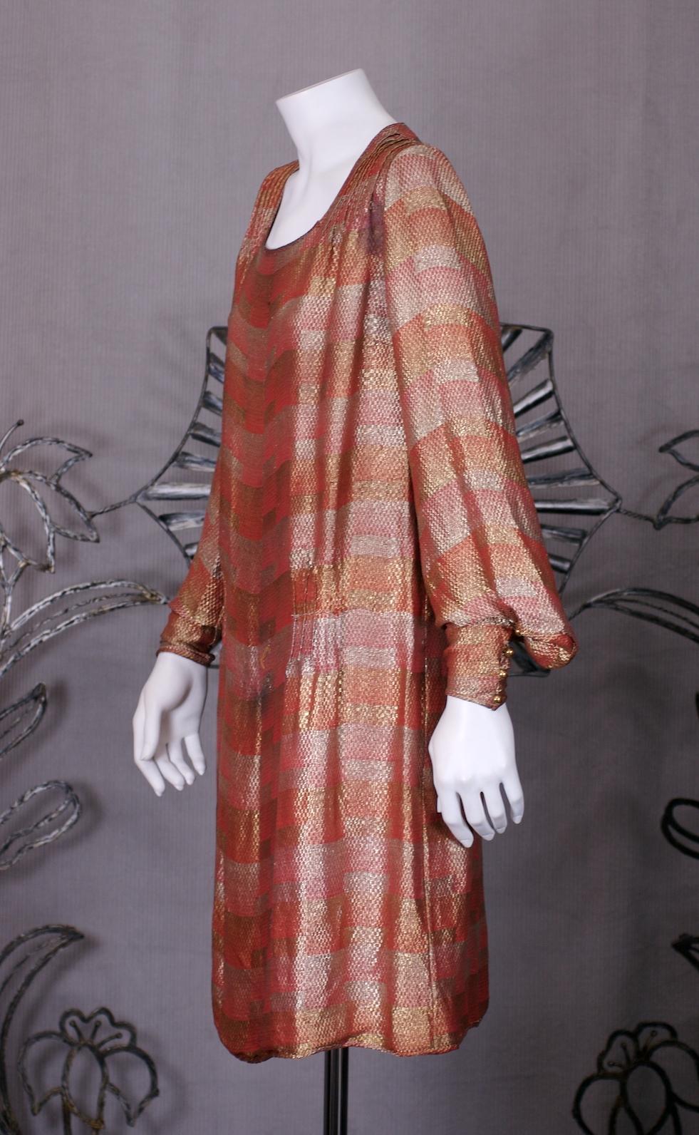 Lucien LeLong Art Deco lame broche cocktail dress about 1925. In autumnal tones, with orangey gold and silver metallic cubist patterns along its horizontal striping. Finely pintucked at shoulder with gold buttoned cuffs and full sleeves. 
Chiffon